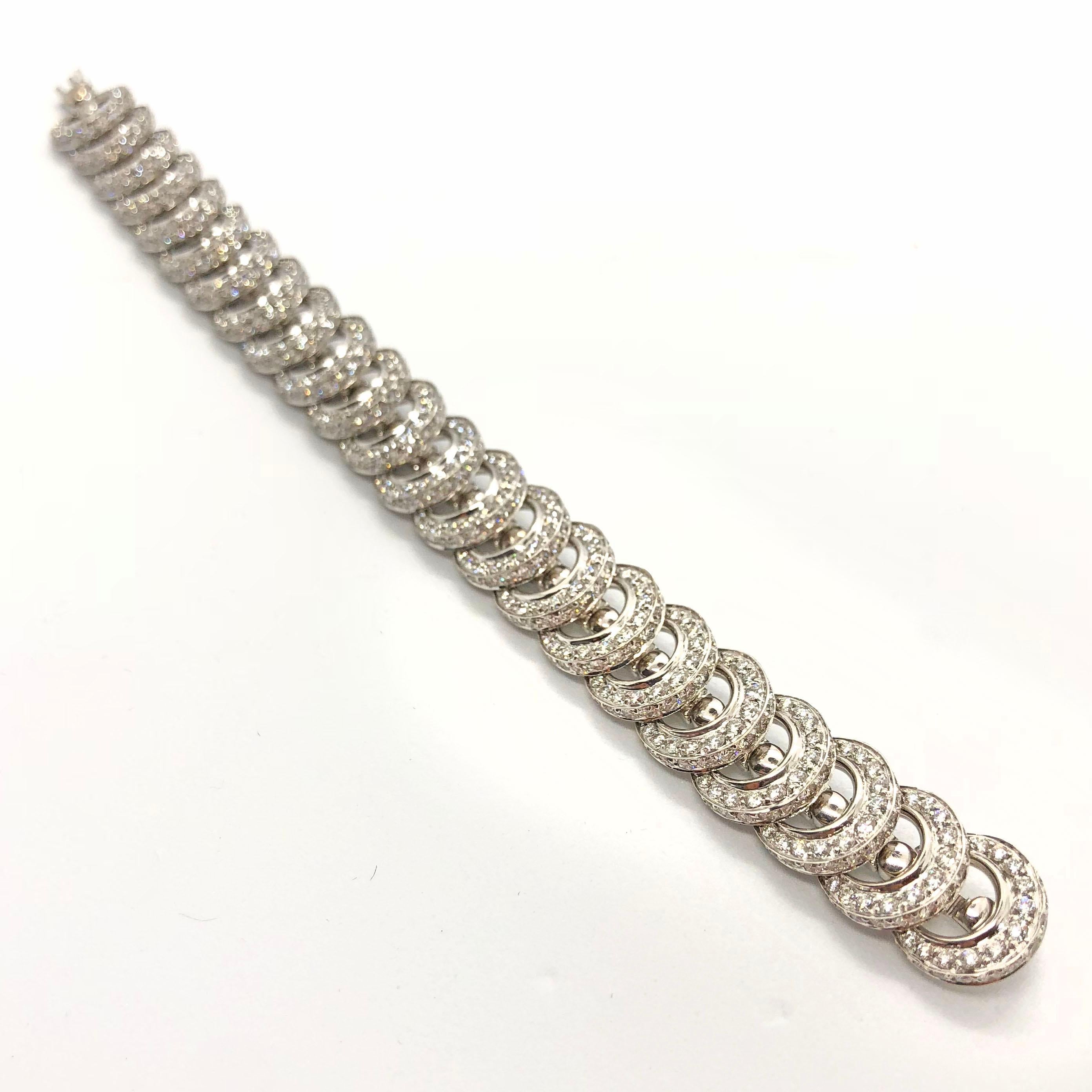 A beautiful diamond bracelet by Cartier in 18k white gold. It is a lovely and playful bracelet, with very fine quality diamonds, ca. 10 carats. Each circle has a fan like motion with diamonds on one side and white gold on the other. The bracelet was