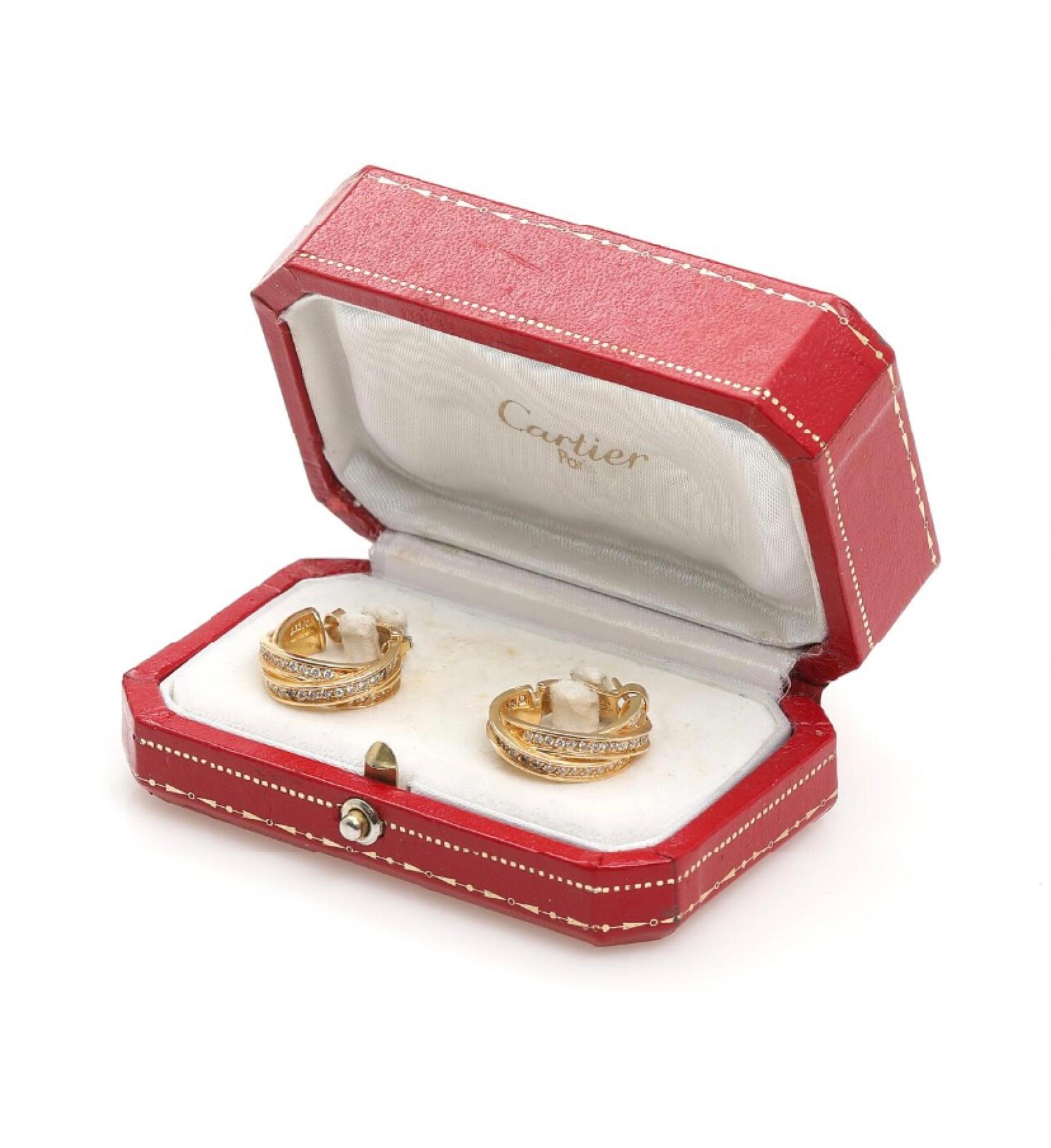 Cartier A pair of “Trinity” diamond earrings set with numerous brilliant-cut diamonds weighing a total of app. 0.90 ct., mounted in 18k gold. Weight app. 17 g. Diam. 2.1 cm. 1987. 

Hallmarks: Cartier, 750
Period: 1987
Accompanied by case and