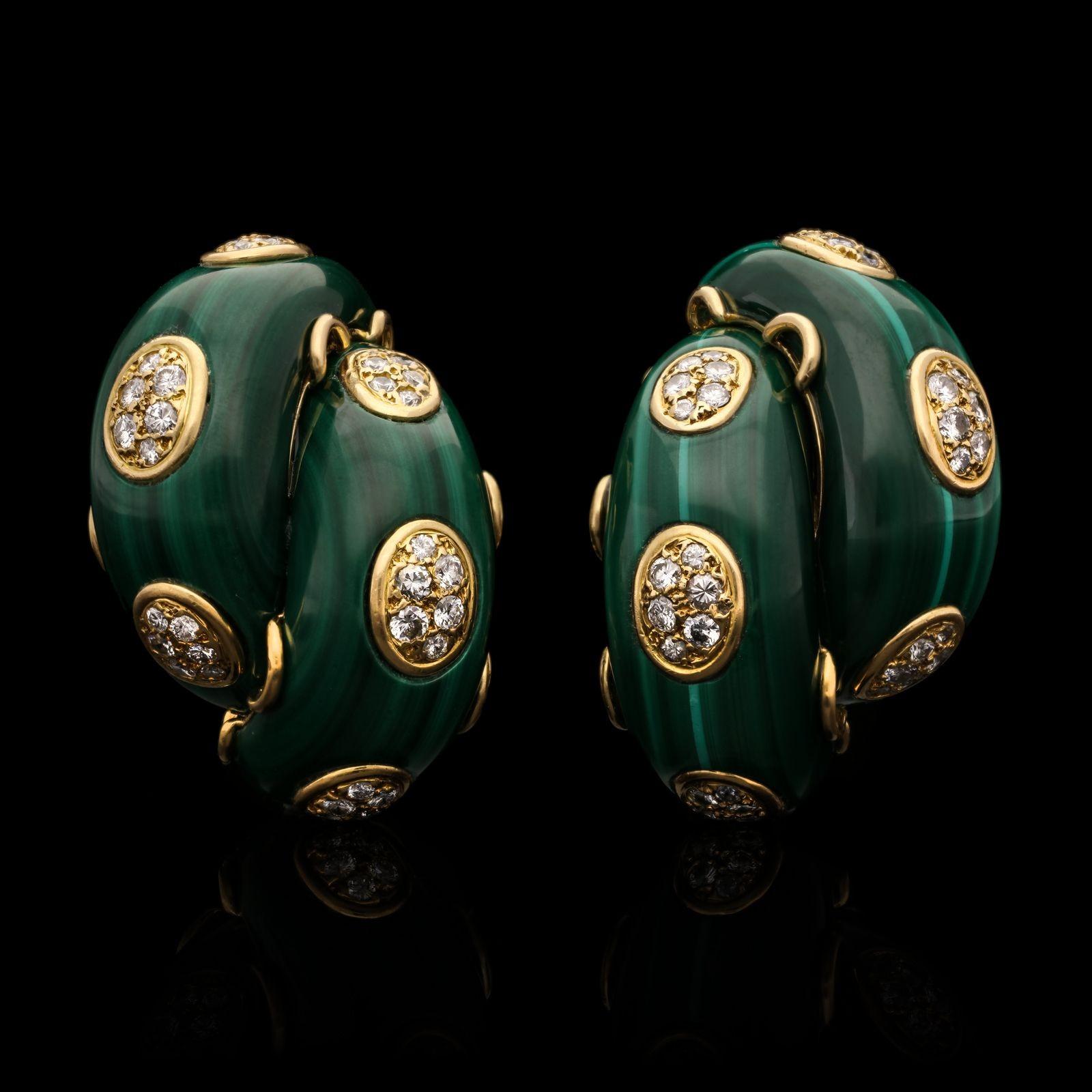 A striking pair of malachite and diamond ear clips by Cartier c.1970s, each earring designed as a double cross over half hoop formed of two domed curves of polished malachite with rounded tapered ends inlaid with gold oval shaped motifs set with