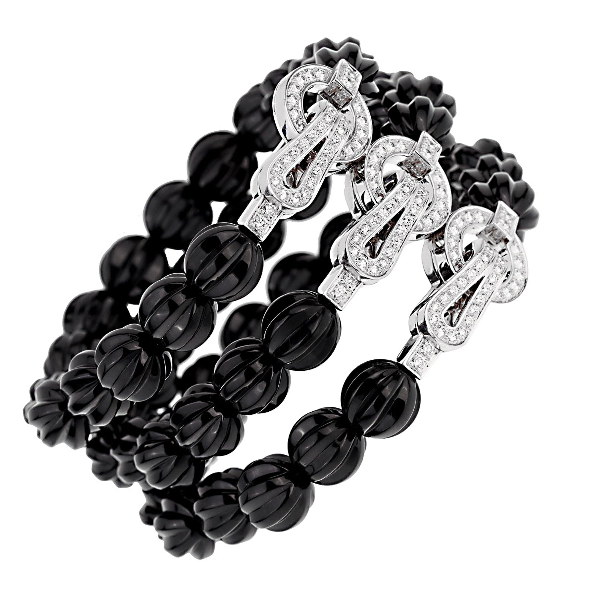 The Cartier Agrafe Diamond Onyx Bracelet is a refined expression of elegance and craftsmanship. Featuring three rows of hand-carved onyx beads, their deep black hue contrasts beautifully with the brilliance of diamonds.

Its centerpiece is the