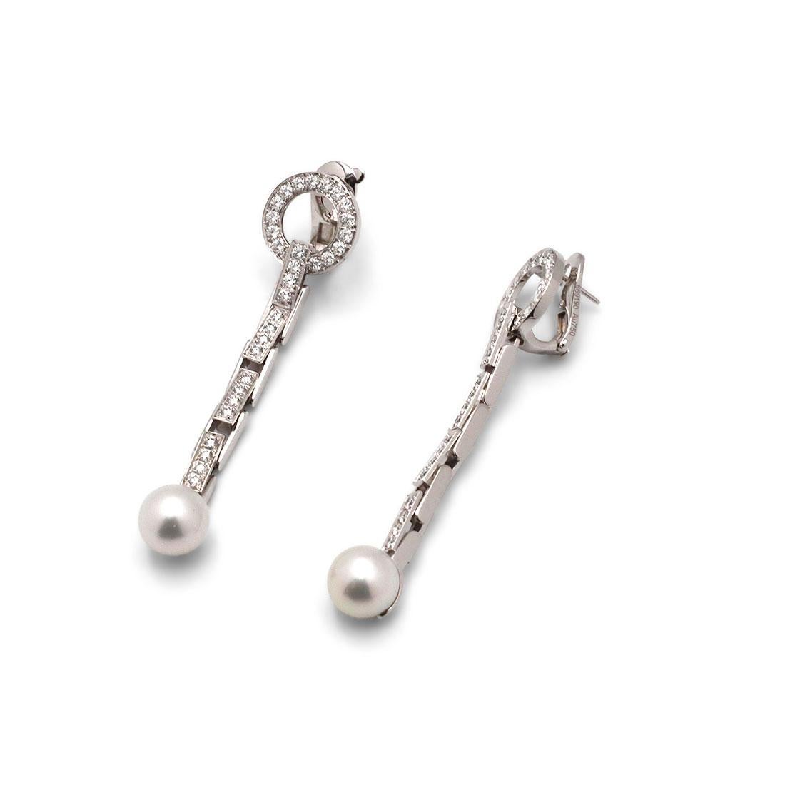 Authentic Cartier Agrafe drop earrings crafted in 18 karat white gold. Brickwork links are pave set with round brilliant cut diamonds weighing an estimated 1.30cttw for the pair. At the end of each earring is a 9.5mm pearl. The earrings measure 2.55