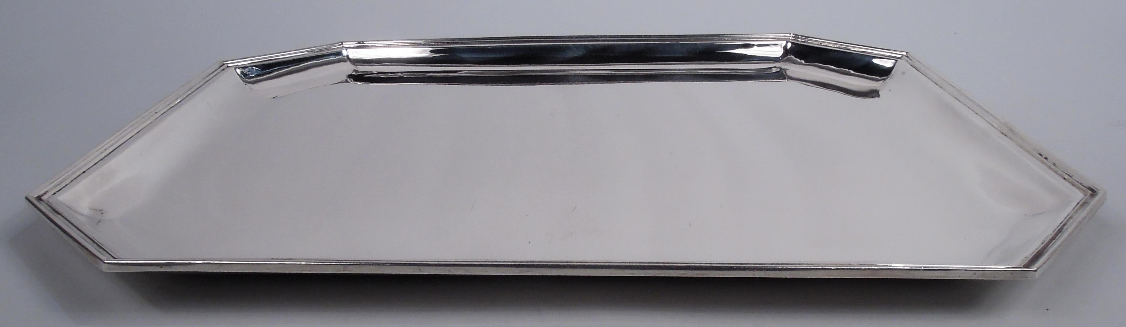 American Art Deco sterling silver tray, ca 1925. Retailed by Cartier in New York. Rectangular with chamfered corners, tapering sides, and molded rim. Fully marked including retailer’s stamp, no. 47/4 and phrase “Hand Made”.  Weight: 43.8 troy ounces.