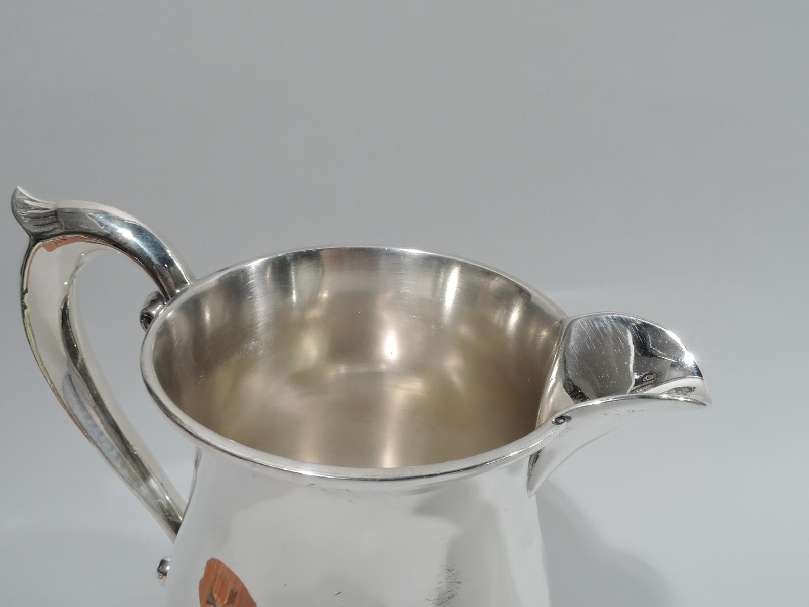 American Colonial-style sterling silver water pitcher, ca 1920. Retailed by Cartier in New York. Baluster body on round stepped foot. Capped s-scroll handle and u-form spout. Marked “Cartier / Sterling / 336”. Heavy weight: 23.5 troy ounces.