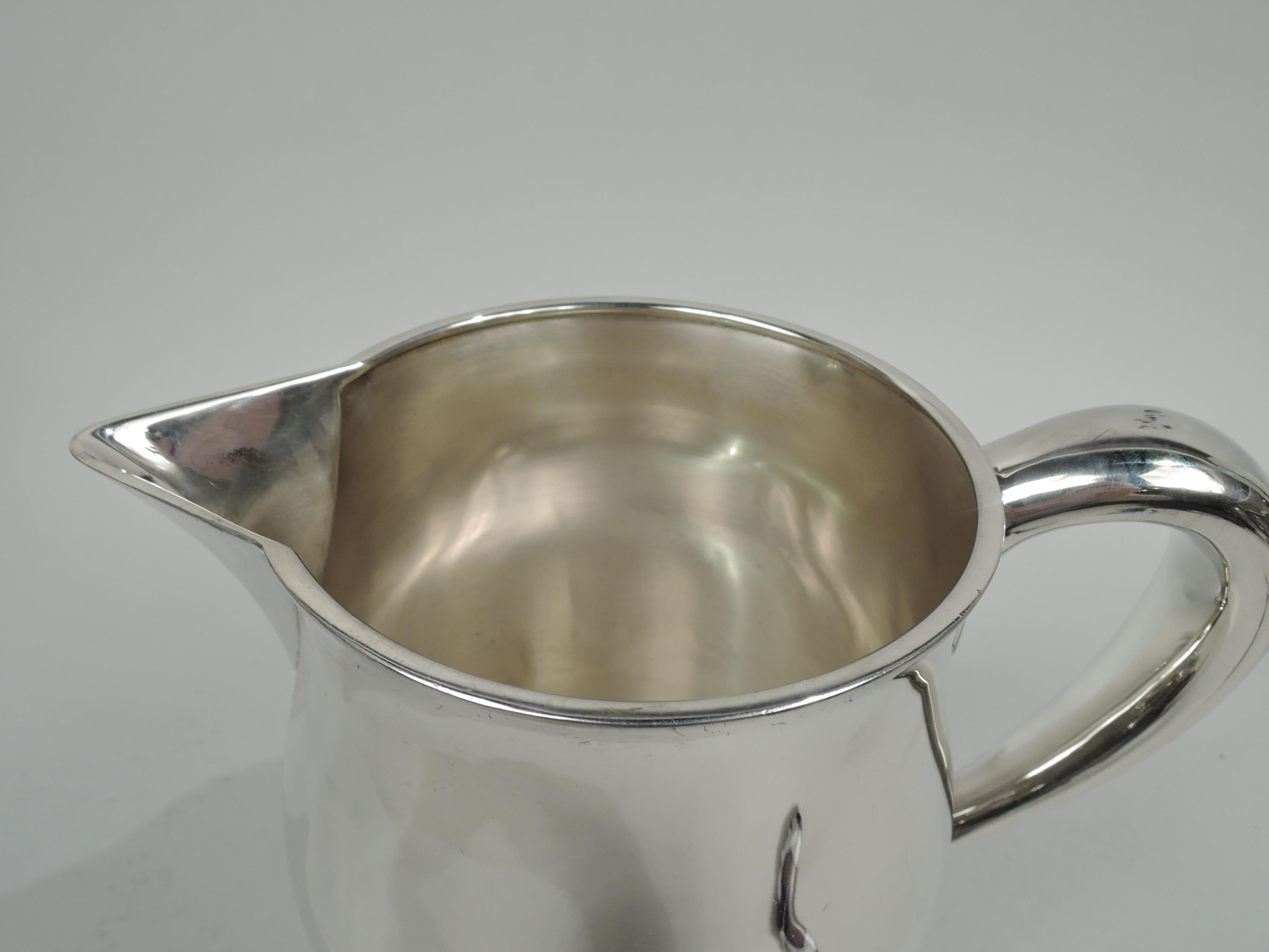 American Federal-style sterling silver water pitcher. Retailed by Cartier in New York, ca 1950. Gently curved body with round mouth, v-spout, and high-looping handle. Fully marked including maker’s (Watson Company) and retailer’s stamps, no. U250,