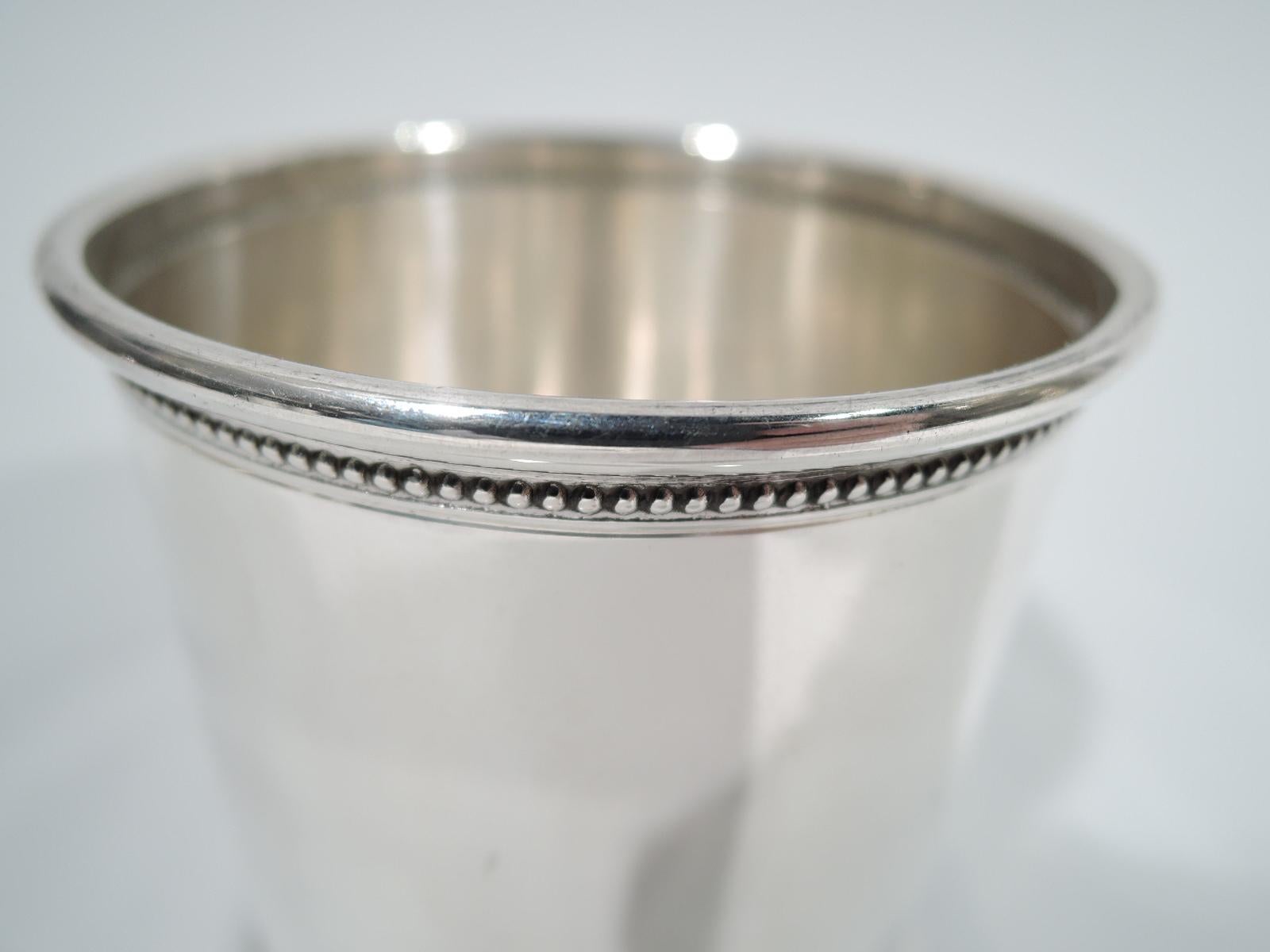 Modern Classical sterling silver mint julep cup. Retailed by Cartier in New York, circa 1930. Drum-form with straight sides. Top rim beeded and bottom rim imbricated leaf-and-berry. The perfect home-alone, lockdown-era solo sipping vessel. Fully