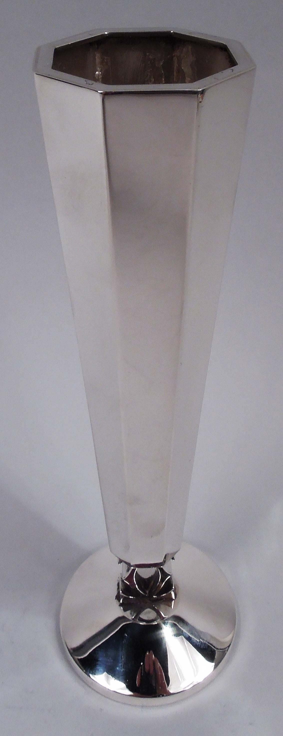 American Modern sterling silver vase. Tapering and faceted bowl and raised round foot. Support in form of two interlaced Cs. C is for Cartier, the world-famous retailer of super stylish wares. Marked “Cartier / Hand Made / Sterling”. Weight: 5 troy