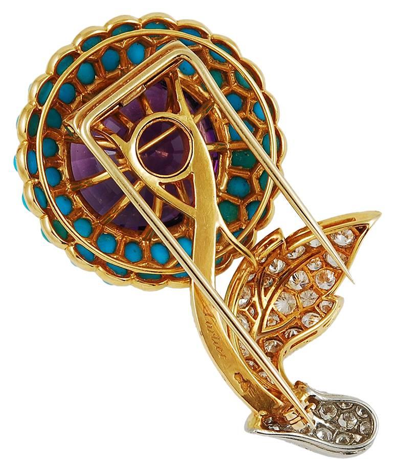 An exquisite brooch designed as a flower centering one round amethyst approx. 35.00 cts., encircled by two rows of round cabochon turquoise, supported by a curved polished gold stem, tipped by gold and platinum-set leaves set with 47 round diamonds