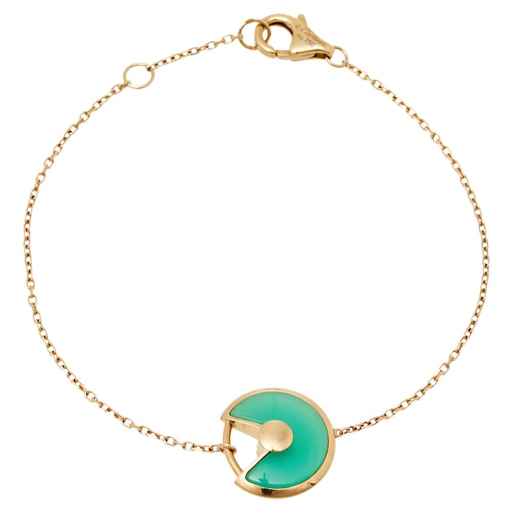 A magnificent offering from Cartier's Amulette de Cartier line. The bracelet comes sculpted from 18k yellow gold and it has the signature motif as the charm inlaid with chrysoprase highlighted by a shimmering diamond. Smoothly finished, the