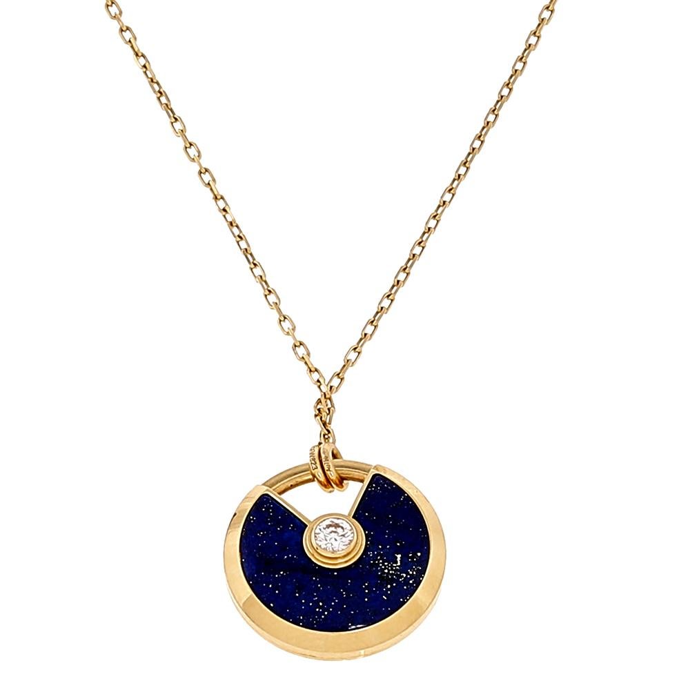 A magnificent offering from Cartier's Amulette de Cartier line. The necklace comes sculpted from 18k yellow gold and it has the signature motif in lapis lazuli highlighted by a shimmering diamond. Smoothly finished, the desirable creation deserves