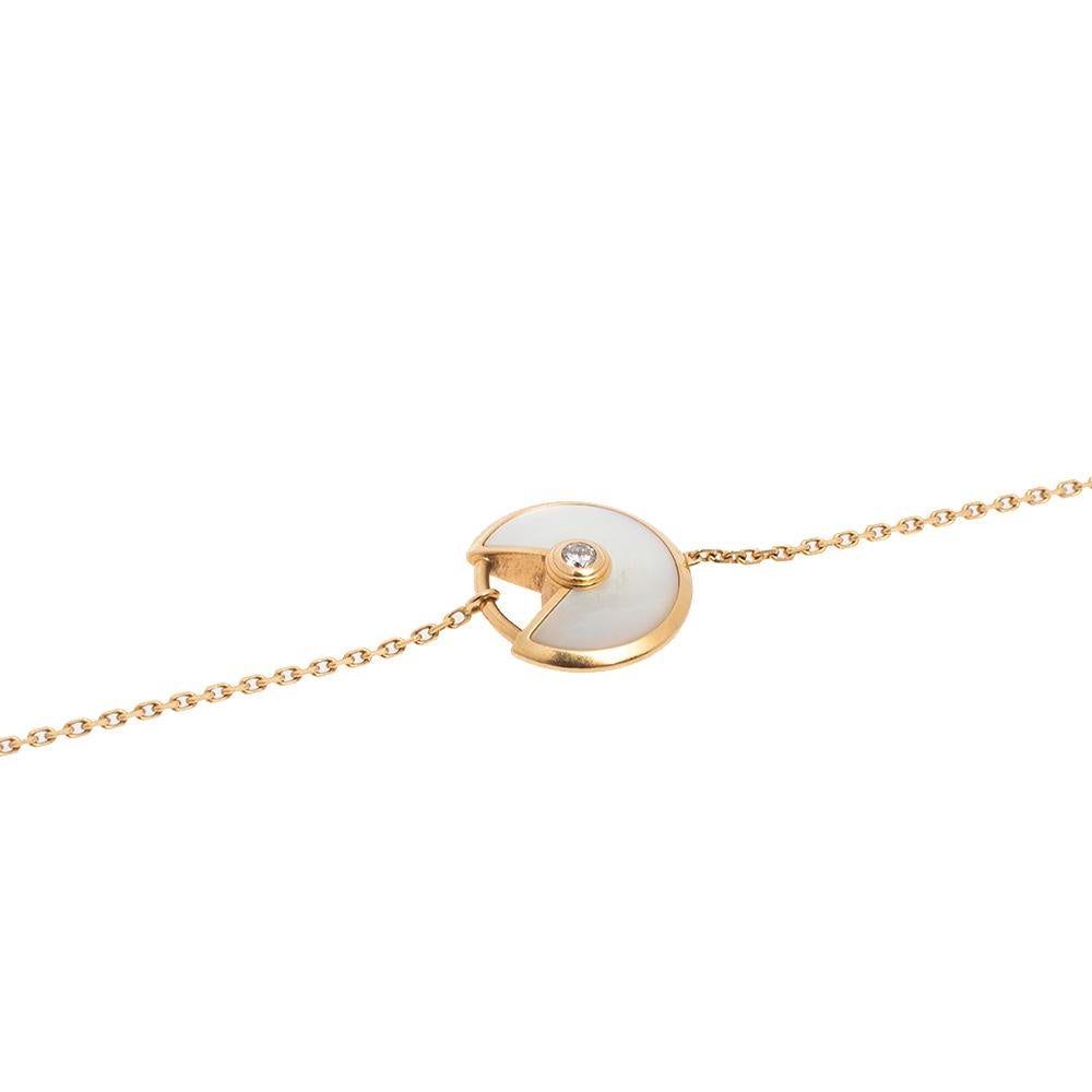 A magnificent offering from Cartier's Amulette de Cartier line. The bracelet comes sculpted from 18k yellow gold and it has the signature motif in mother of pearl highlighted by a shimmering diamond. Smoothly finished, the desirable creation