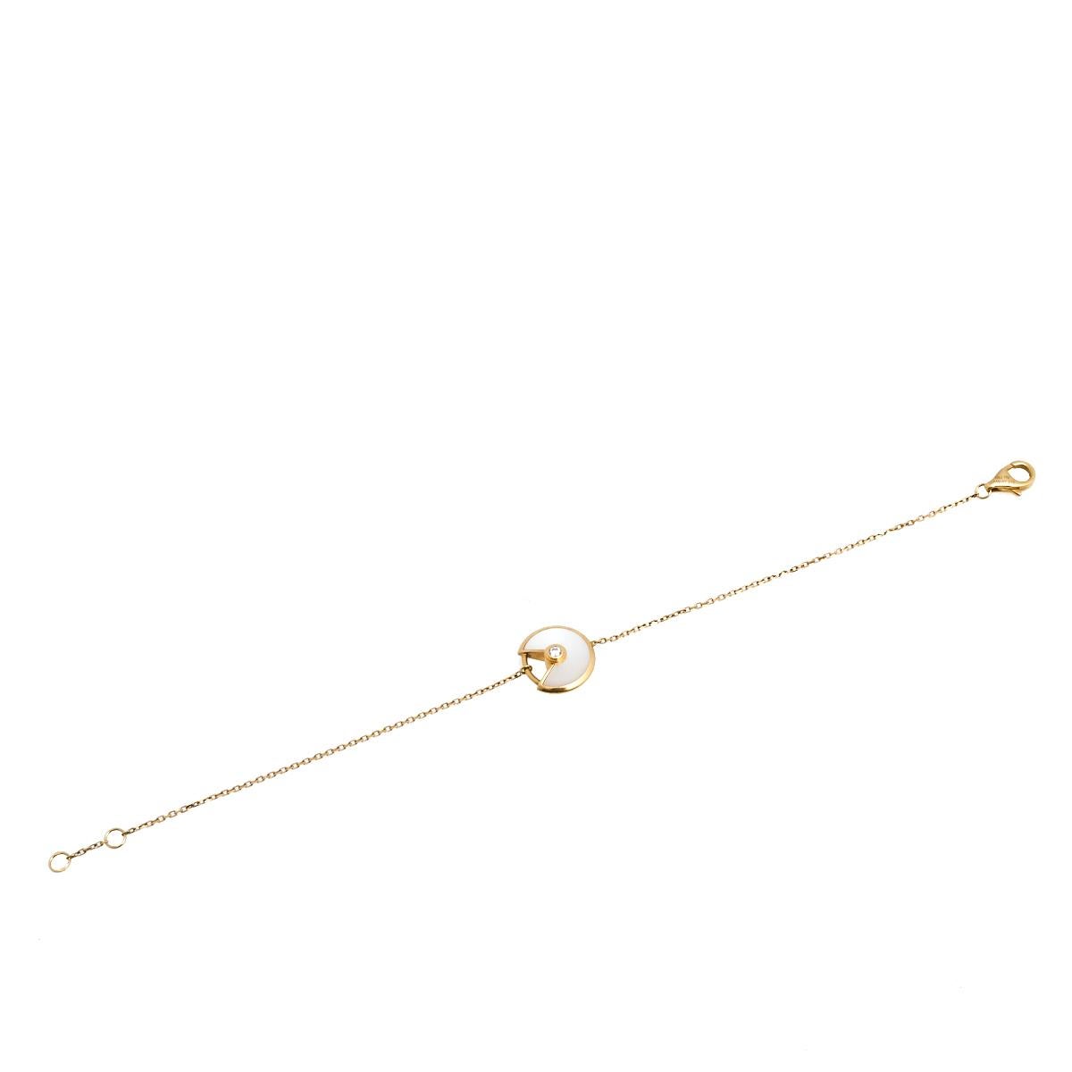 A minimal yet magnificent offering from Cartier's Amulette de Cartier line. The bracelet comes sculpted in 18k yellow gold and it has the signature motif in mother of pearl highlighted by a shimmering diamond. Smoothly finished, the desirable