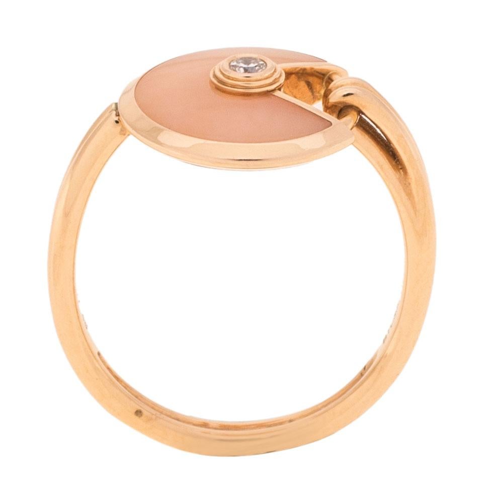 A magnificent offering from Cartier's Amulette de Cartier line. The ring comes sculpted from 18k rose gold and it has the signature motif in pink opal highlighted by a shimmering diamond. Smoothly finished, the desirable ring deserves to be yours.