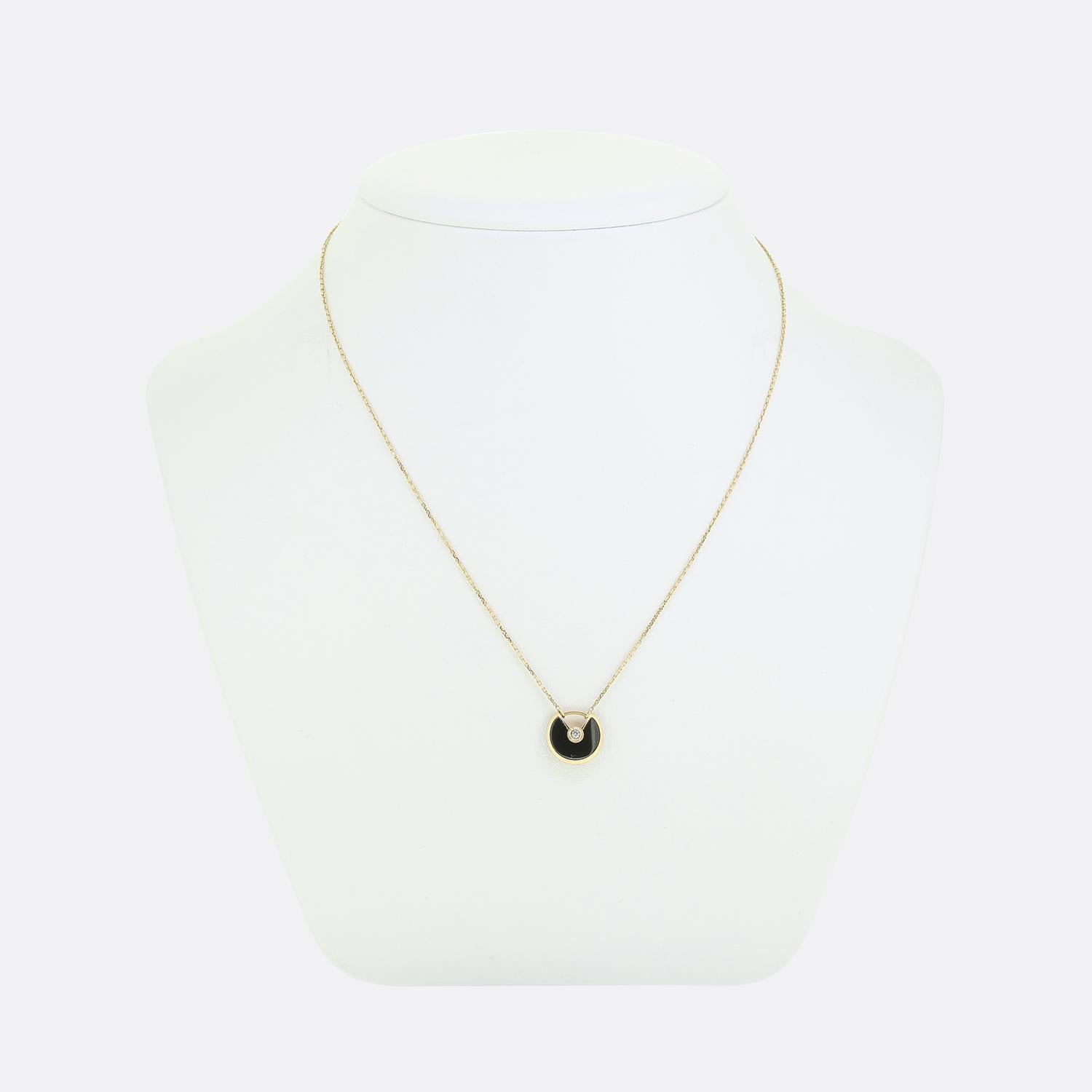 Here we have a fabulous necklace from the world renowned jewellery house of Cartier. This pendant forms part of their iconic 'Amulette' collection and features a single round brilliant cut diamond atop a onyx backdrop. This piece is then suspended