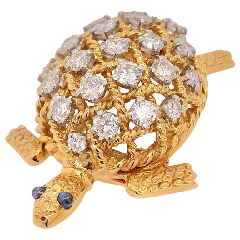 A Vintage Diamonds and Sapphires Brooch by Cartier in 18 Karatt yellow gold modelled as a turtle. Its shell jewelled with brilliant-cut diamonds and its eyes with blue cabochon sapphires, signed Cartier Paris and numbered, French assay marks