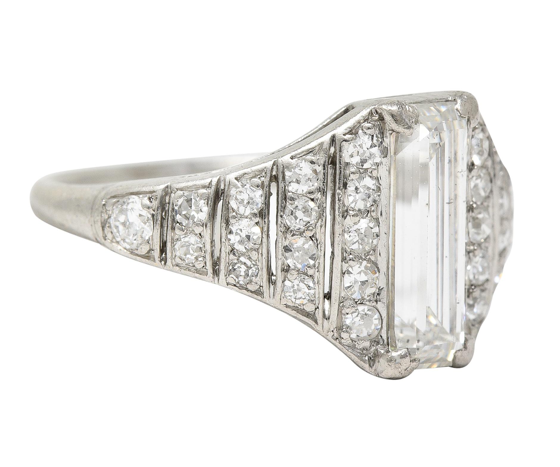 Centering a baguette cut diamond weighing approximately 1.41 carats - G color with SI1 clarity. Prong set and flanked by pierced tapered shoulders with rows of bead set diamonds. Old European cut and weighing approximately 0.34 carat total. G/H