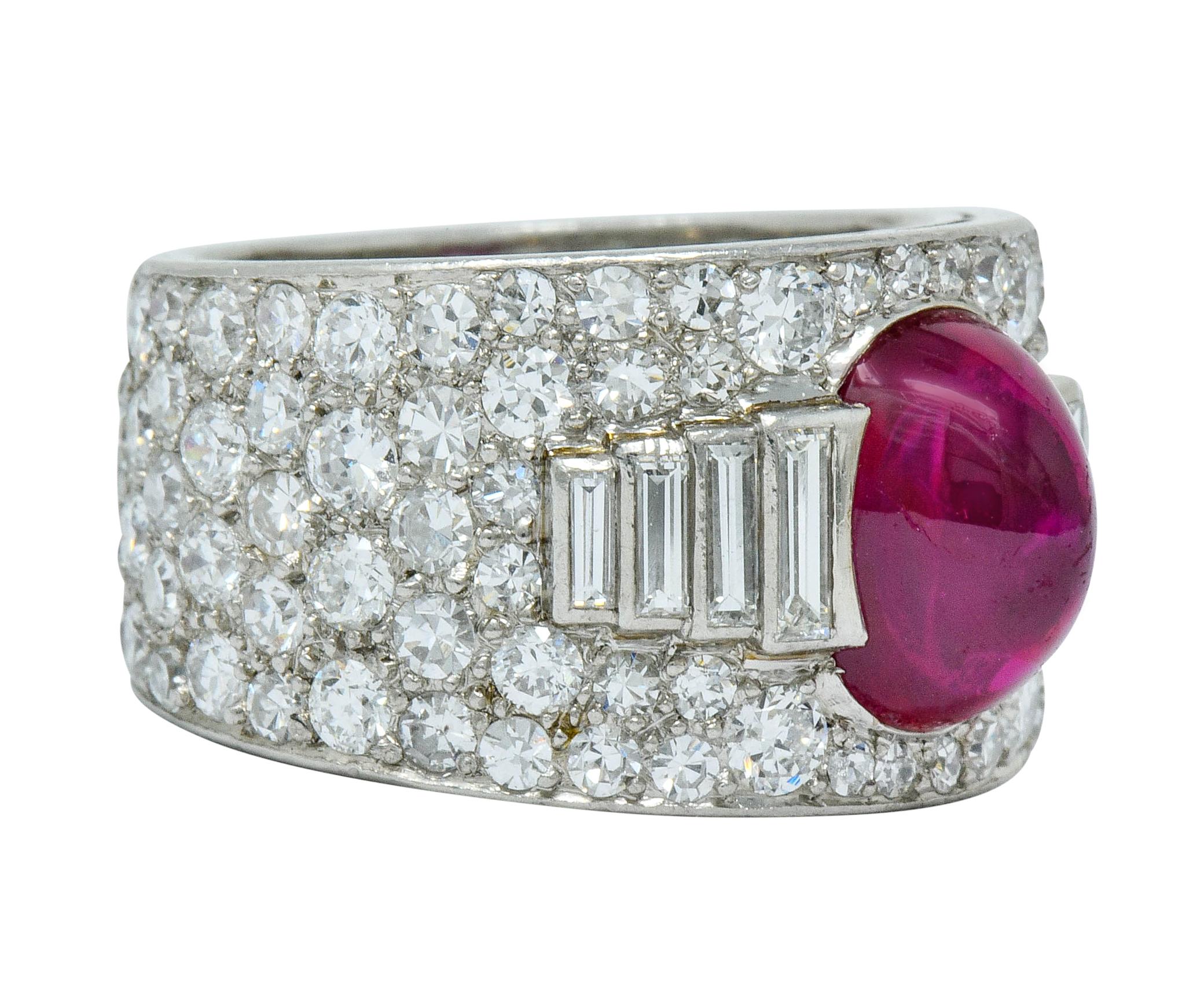 Centering a bullet cabochon Burma ruby weighing approximately 4.50 carats

Natural bright red color with no indications of heat

Flanked by bar set baguette cut diamonds, graduating in size, weighing approximately 0.45 carat total; H/I color with