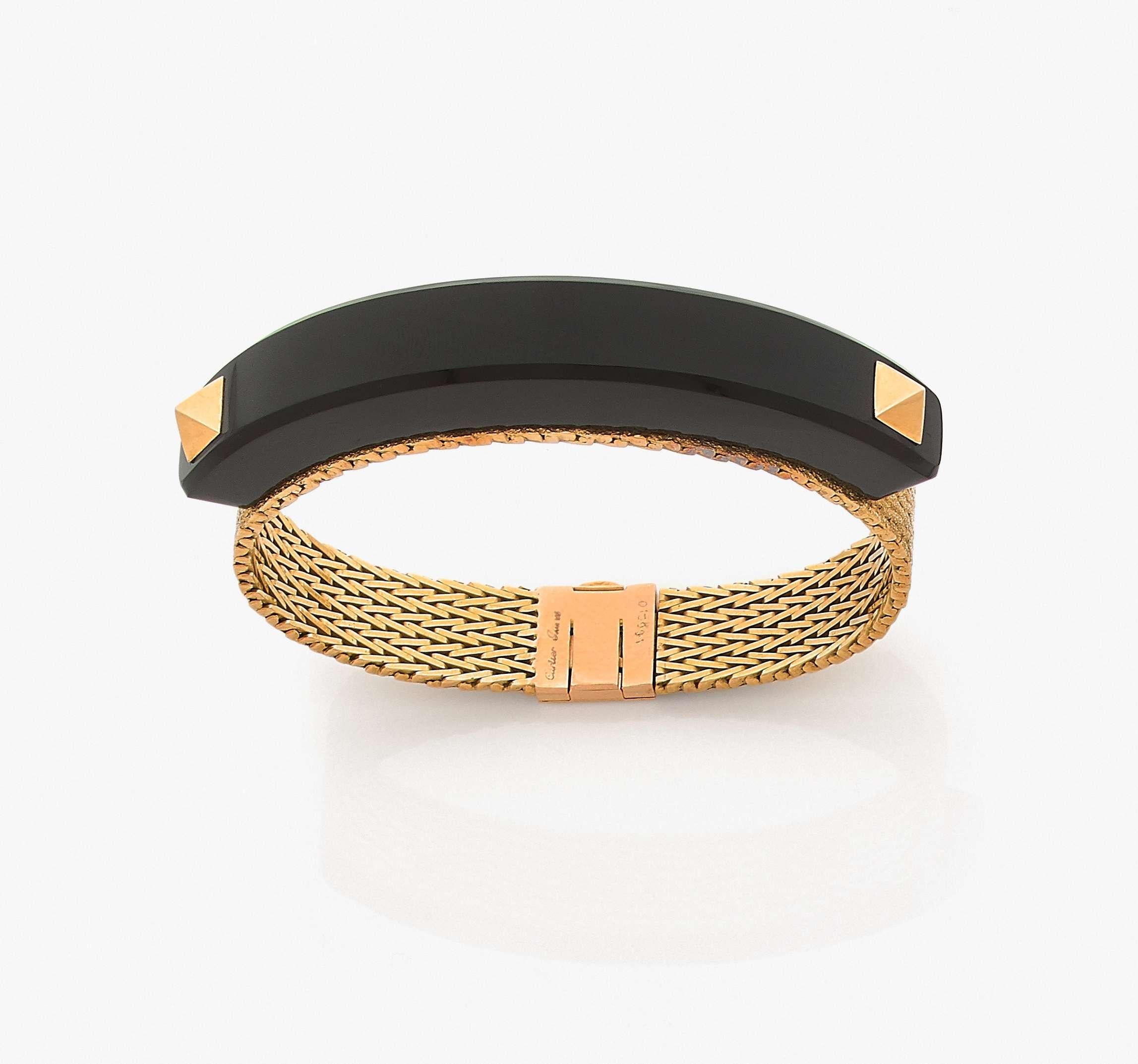 Cartier Art Deco Bracelet in 18k yellow gold with an onyx arch on top of it presenting two pyramidal studs. 

Signed Cartier Paris 186210.
