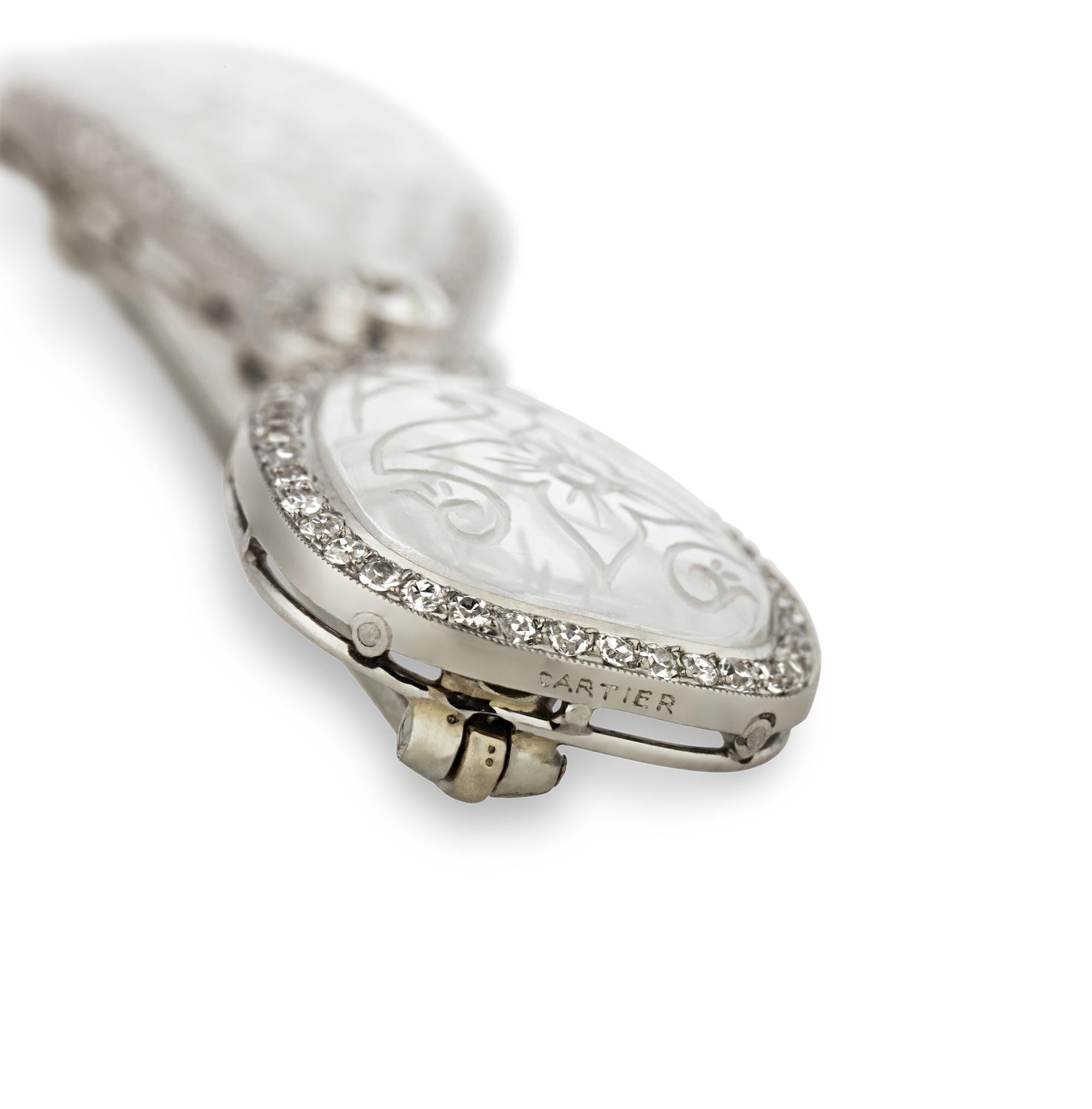 Exhalant la décadence de l'ère Art déco, cette broche est l'œuvre du célèbre joaillier français Cartier. Prenant la forme d'un nœud classique, l'épingle est réalisée en cristal de roche avec des motifs décoratifs délicatement sculptés. Soulignée de