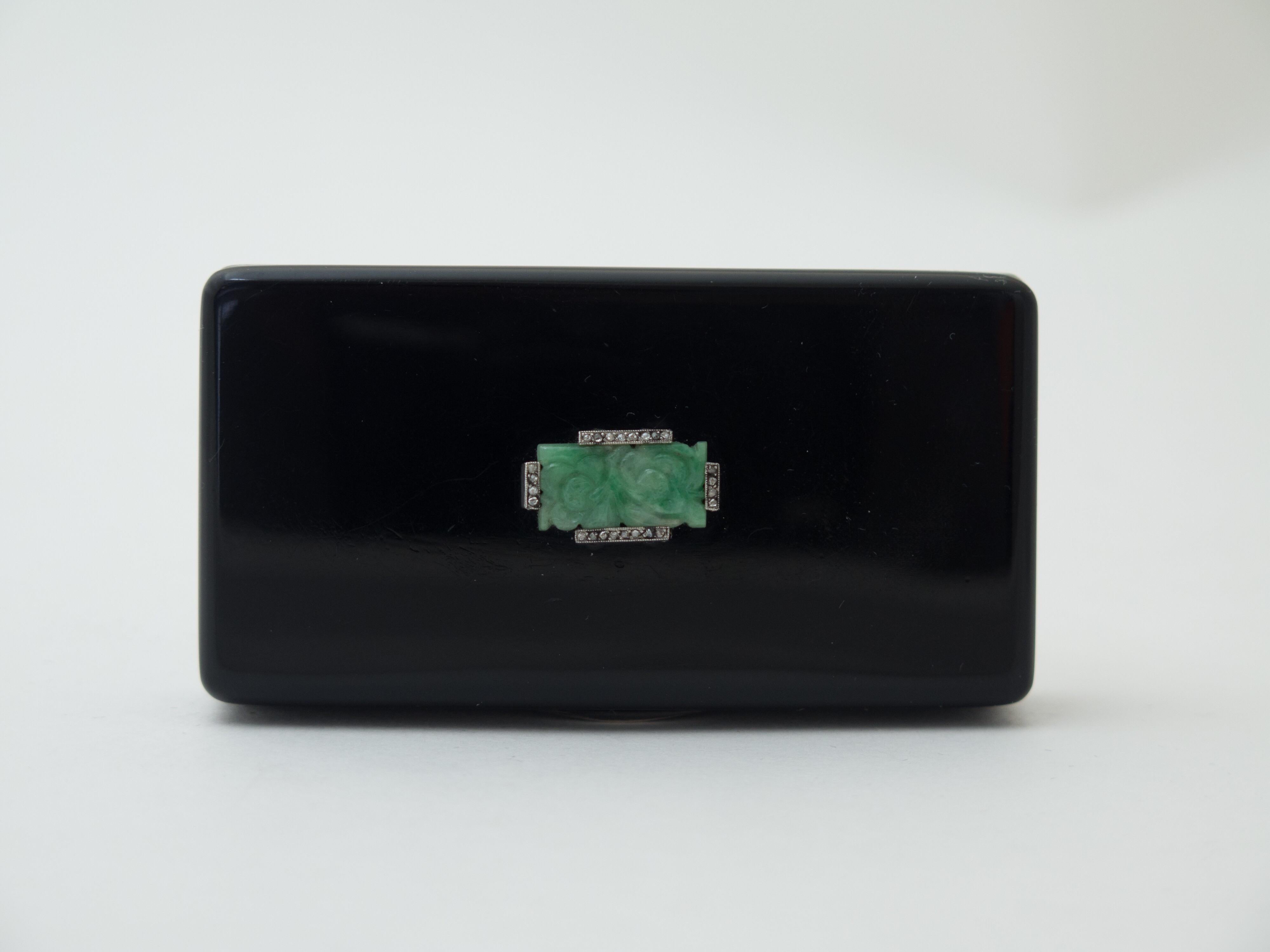A rare Cartier art deco period black enameled sterling silver box set with carved foliate jade tablet surrounded by rose cut diamonds. Gilt interior. 
Size: 3