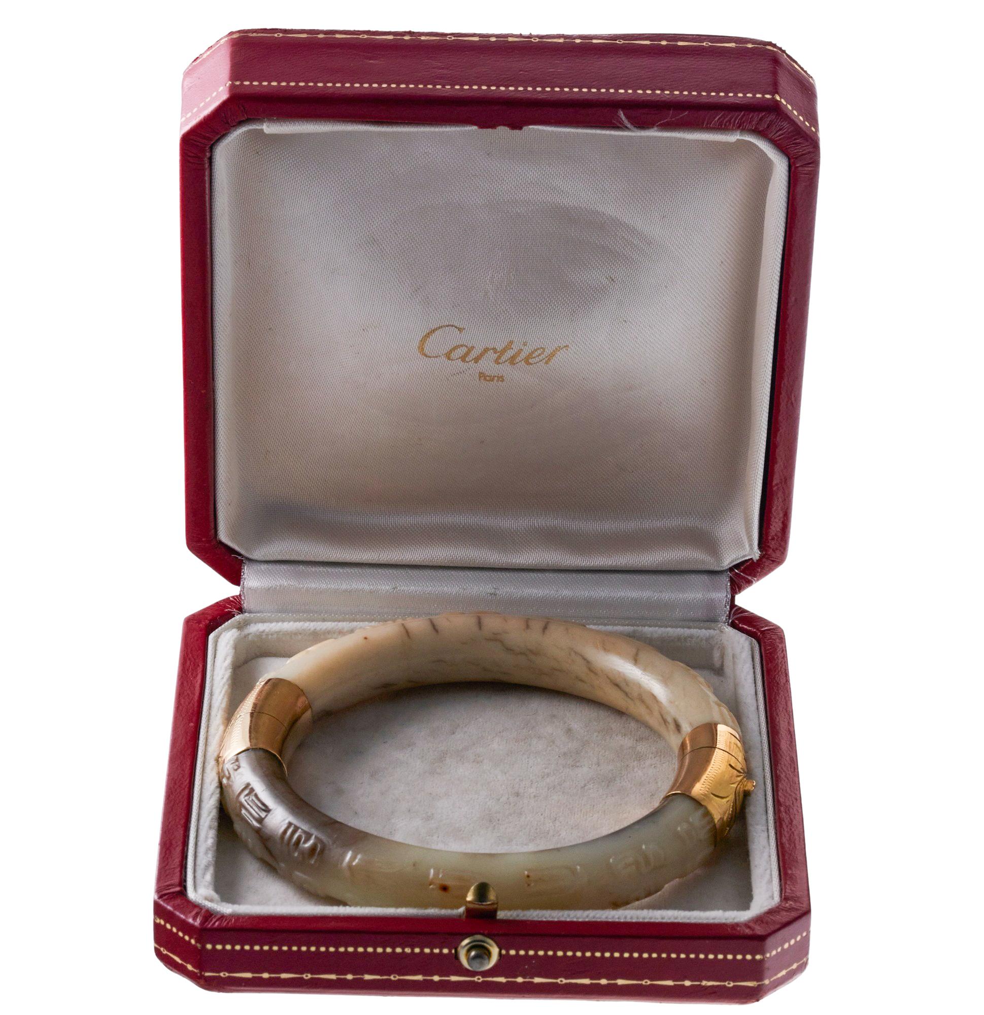 Antique Cartier 18k gold bangle bracelet, featuring carved jade. Comes in original antique box - wear consistent with age.  Bracelet will fit approx. 7
