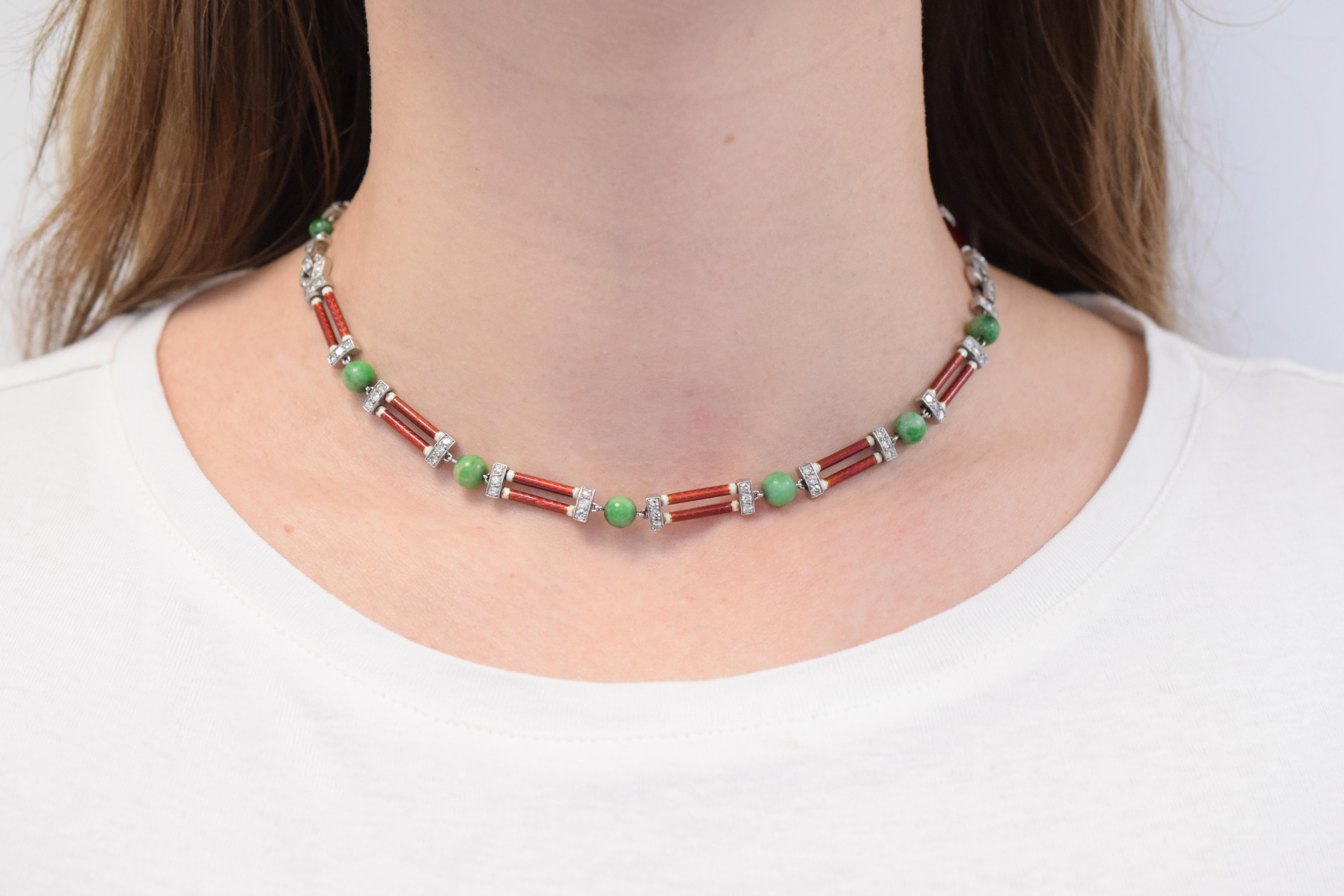  Cartier Art Deco Jade Necklace Composed of jade beads interspersed with baton-shaped links applied with red guilloché enamel and white enamel, accented with single-cut diamonds a total of approximately 0.85 carats, finished with two buckle- shaped