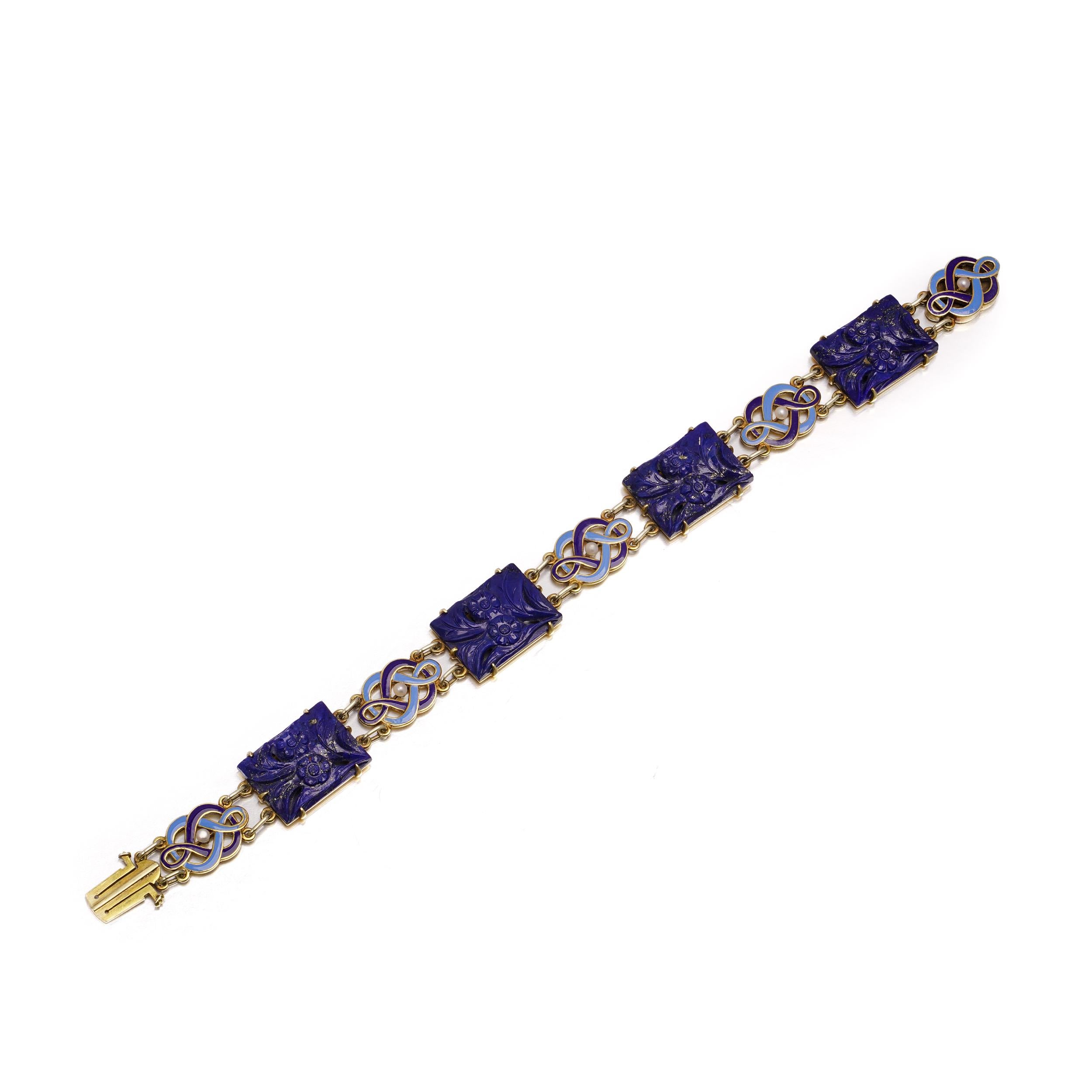A rare Art Deco bracelet by Cartier, crafted in 14kt yellow gold and composed of four hand-carved floral lapis lazuli plaques alternating with five blue guilloché enamel scroll motifs, each centered by a seed pearl. The reverse of the lapis plaques