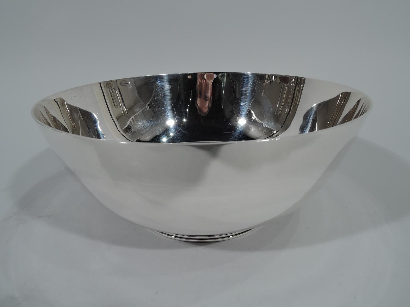Art Deco sterling silver bowl. Retailed by Cartier in New York, circa 1930. Tapering and curved bowl. Inset circular foot with horizontal ribbed bands. A stylish design with the exciting element discreetly tucked under. Hallmark includes no. 227X.