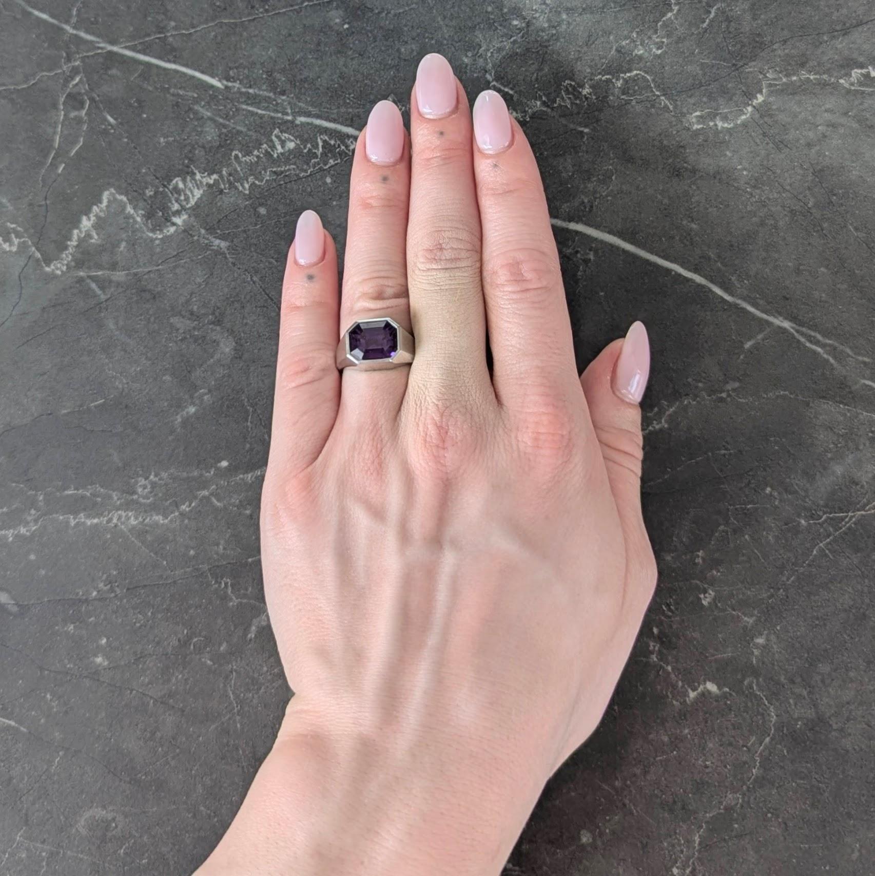 Im Zentrum ein Saphir im Smaragdschliff mit einem Gewicht von 7,83 Karat - bündig eingefasst in ein achteckiges Siegelgesicht
Transparentes mittleres Violett mit starkem Farbwechsel von Violett nach Rot unter Glühlampenlicht
Natürliches Ceylon (Sri