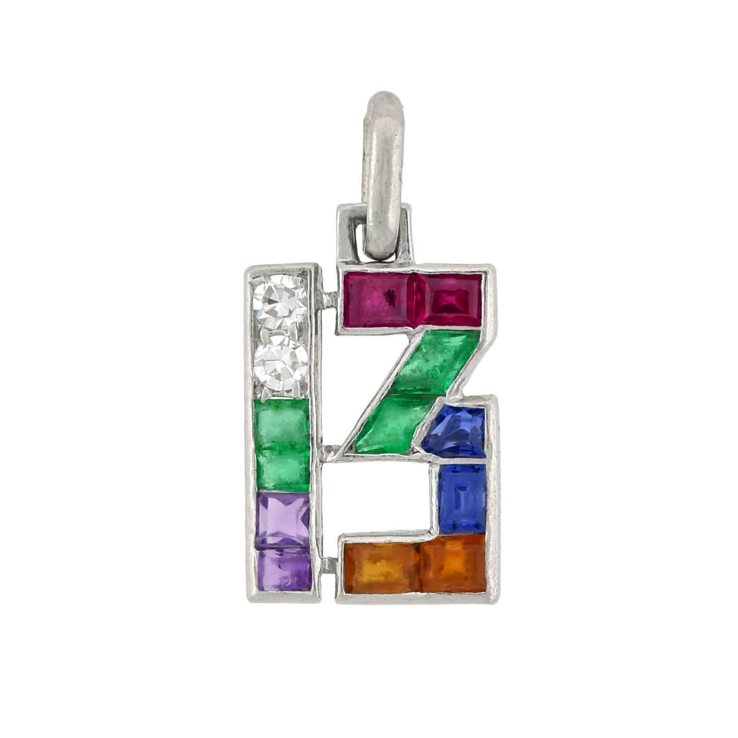 A wonderful multi-gemstone lucky number charm pendant from the Art Deco (ca1920s) era! By Cartier London, this fabulous piece is crafted in platinum and forms the shape of the number 