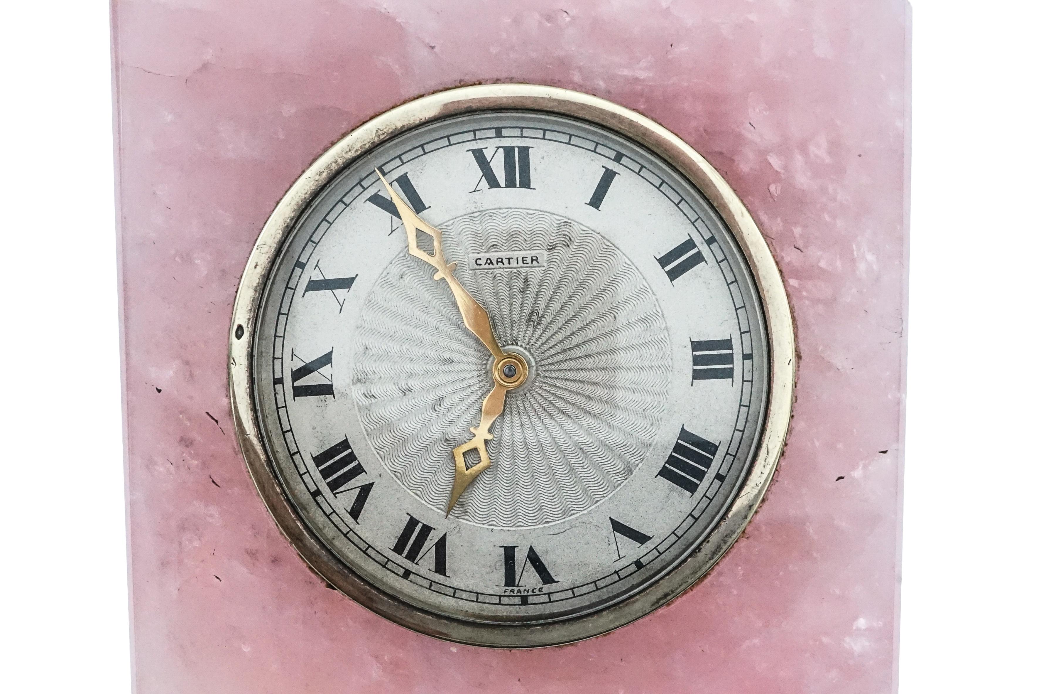 An Art Deco Cartier Rose Quartz Desk Clock. Bezel and hands are gold; dial has Roman numeral indices; measures 10.7 x 7.8 x 2.7cm; weight: 494.5g. Signed Cartier on the dial.

SKU#O-00631
