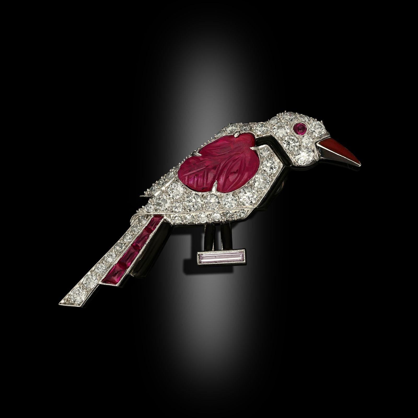 An Art Deco stylised bird brooch by Cartier London circa 1925. The brooch is designed as a standing bird in profile, it is set with old European cut diamonds, a carved ruby as a wing, accents of onyx, buff top rubies and a cabochon ruby eye, the