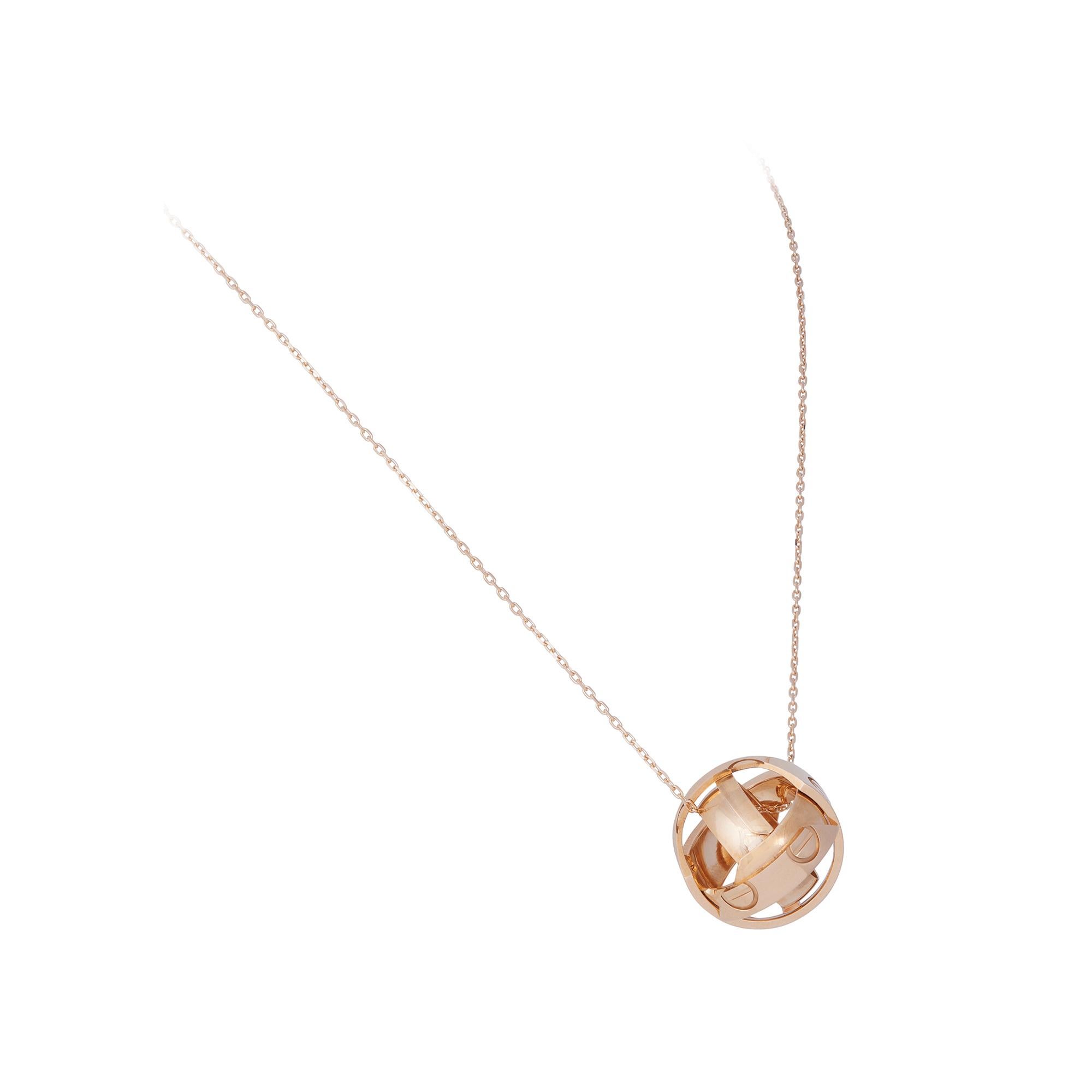 Authentic Cartier Astro Love ring crafted in 18 karat yellow gold.  The wide band converts into a spherical pendant and is accompanied by a Cartier chain measuring an adjustable 19 inches.  Size 51, US 5 3/4.  Signed Cartier, 1999, 750 with serial