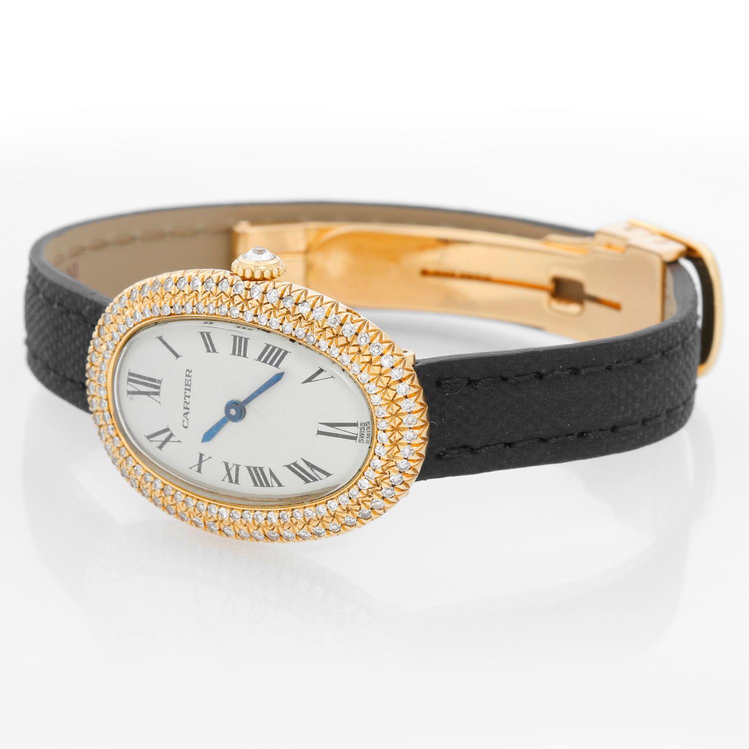 Montre Cartier Baignoire en or jaune 18 carats - Remontage manuel. Or jaune 18 carats avec lunette en diamants de Cartier. Cadran ivoire avec chiffres romains. Nouveau Bracelet Cartier noir avec fermoir déployant en or jaune. D'occasion avec