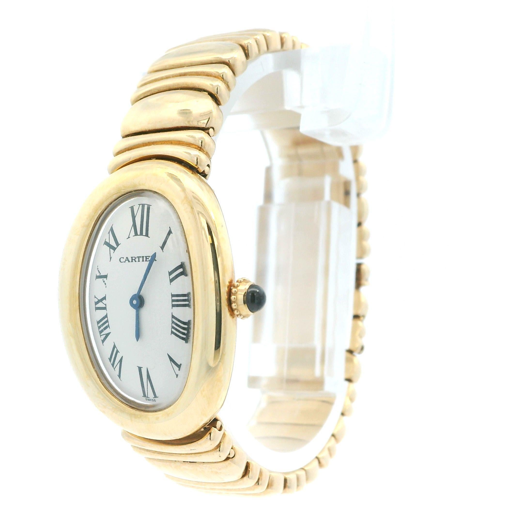 Cartier Baignoire 1952 Ladies Watch. 22mm by 30mm 18k Yellow Gold case non bezel. Ivory dial with blue hands and roman numeral hour markers. 18K Yellow Gold bracelet with hidden Butterfly Clasp fit to a 5.75-inch wrist. Sapphire Crystal, 18K yellow