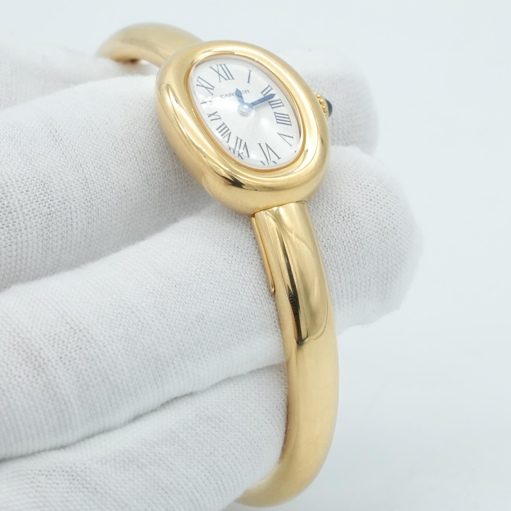 Baignoire de Cartier watch, mini model, size 16, quartz movement. 18K yellow gold (750/1000) case. 18K yellow gold (750/1000) beaded crown set with a sapphire cabochon. Silvered dial, blued-steel sword-shaped hands, sapphire crystal. 18K yellow gold