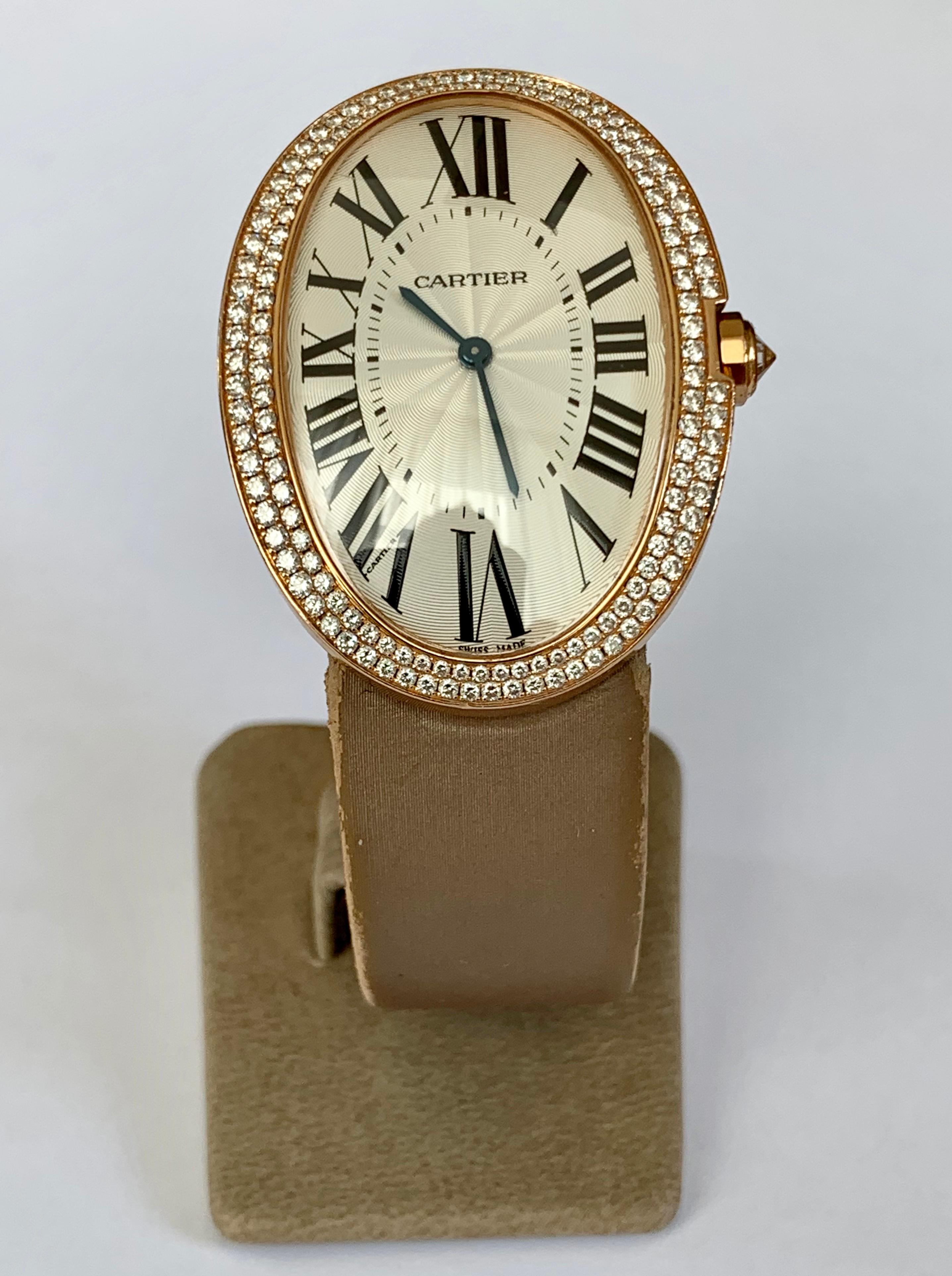 Pre-Owned Cartier Baignoire, large Model, mechanical movement, features a 34mm x 44mm 18k pink gold case with a diamond bezel surrounding a silver dial on a goldbrown satin strap with an 18k pink gold deployant buckle. Set with 149 brilliant-cut