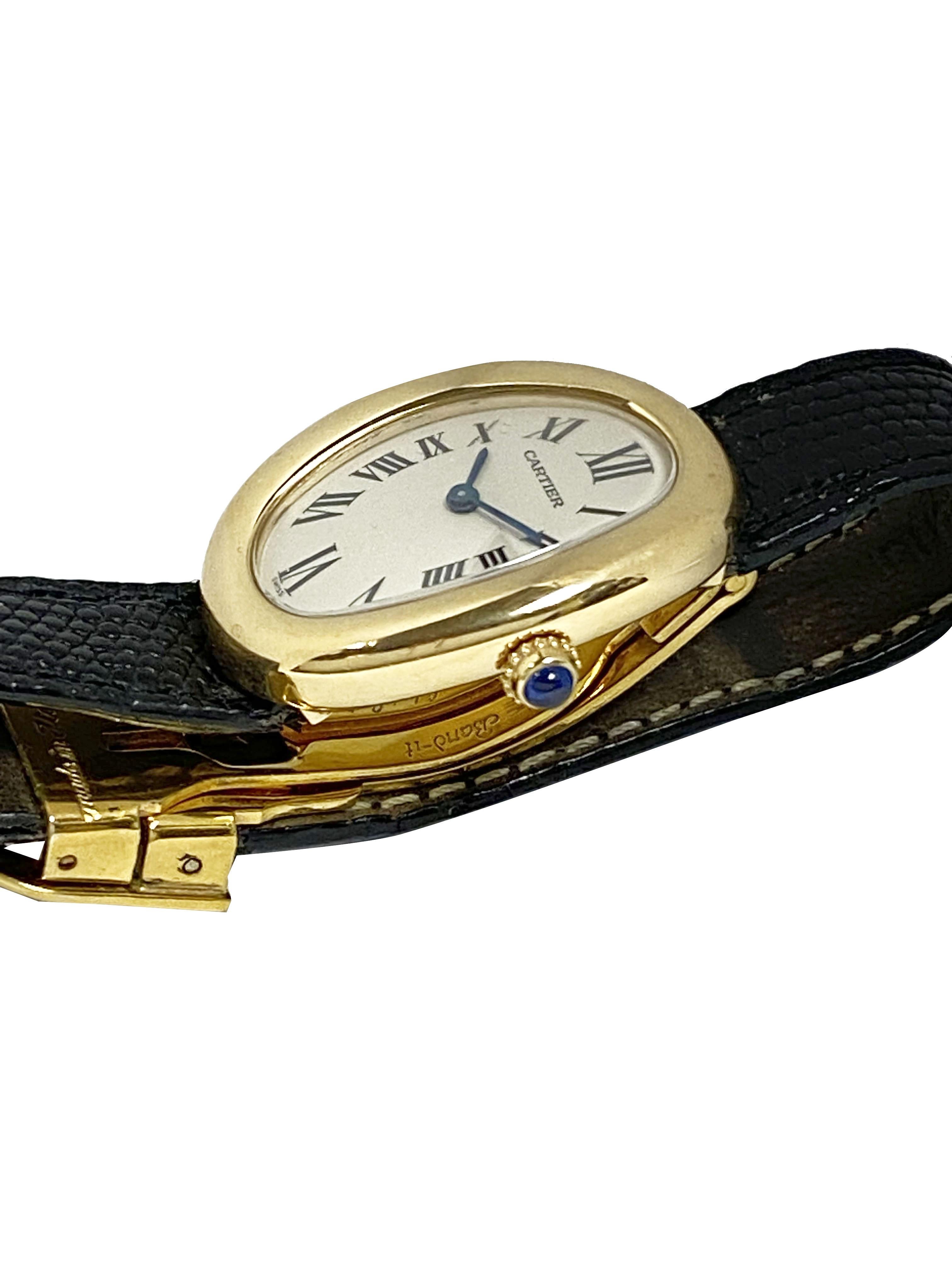 Circa 1990 Cartier Baignoire Wrist watch. 31 X 23 M.M 18K Yellow Gold 2 piece water resistant case. Quartz movement,  White dial with Black Roman Numerals, Sapphire Crown.  Black Lizard Strap with Gold plate Deployment buckle. Watch length 7 