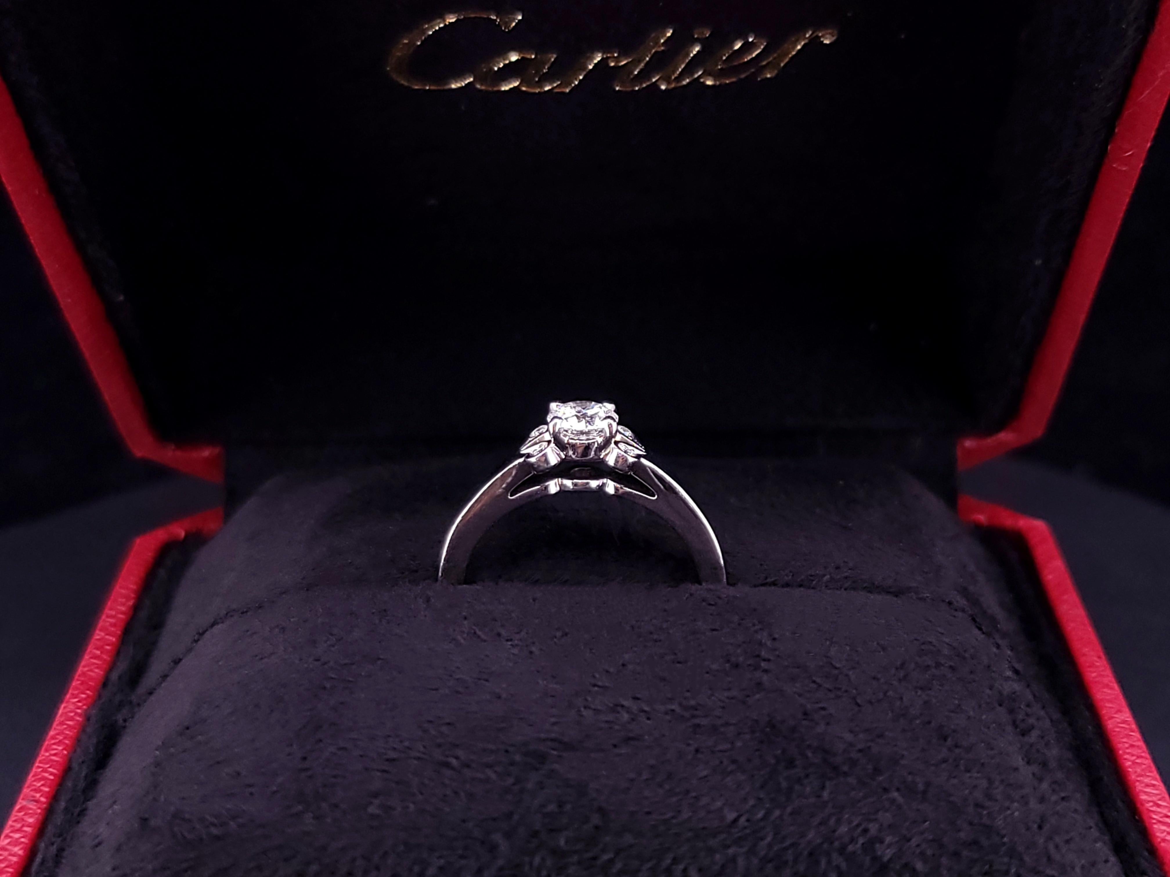 Anello di fidanzamento solitario Cartier Ballerine 
Stile: Solitario con pietre laterali
Materiale: Platino950
Misura dell'anello: 5
TCW: 0,35 tcw 
Diamante centrale: Diamante tondo Brilliante 0,32 carati 
4 diamanti rotondi da 0,03 tcw
Grado di