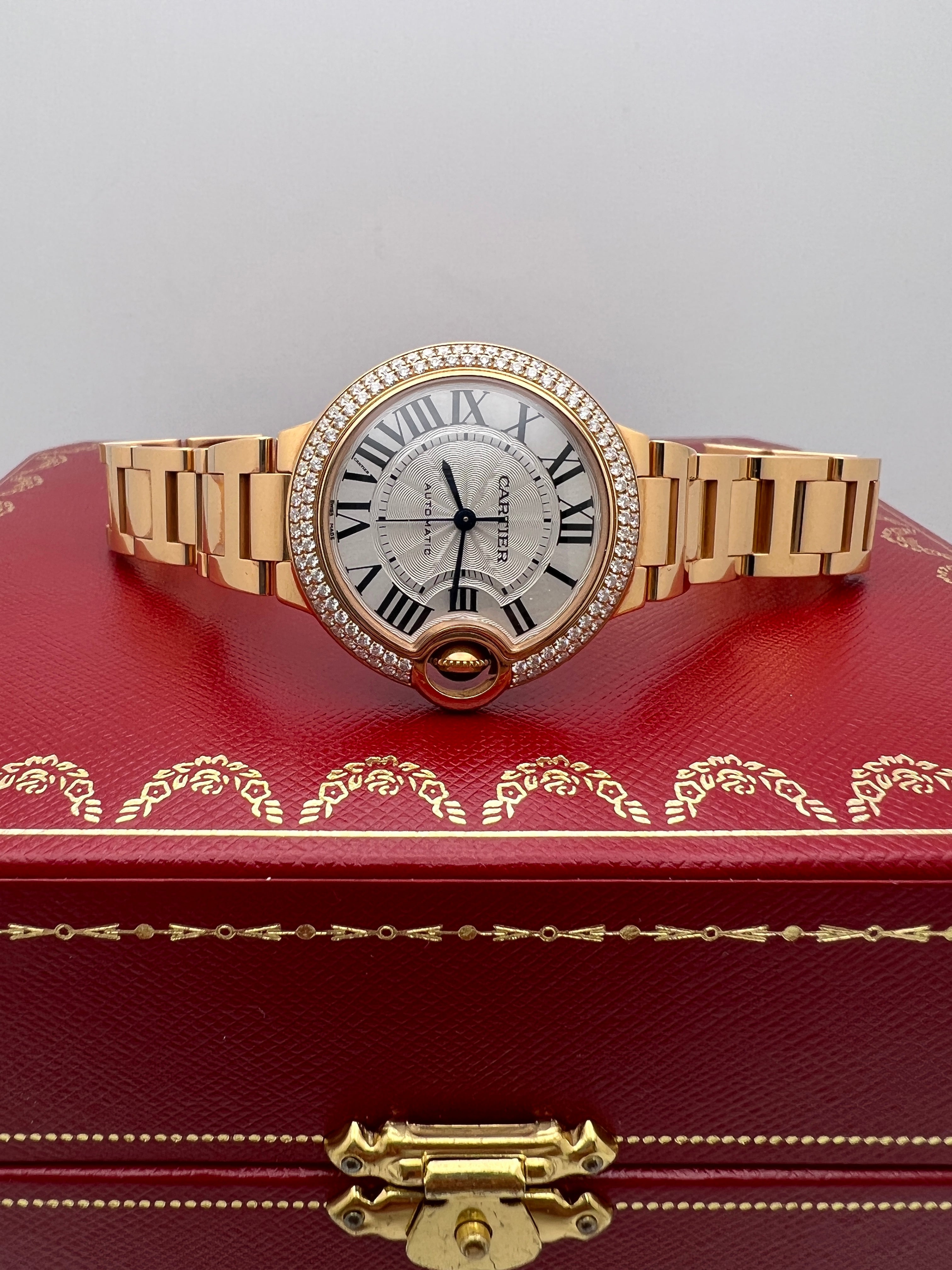 El Cartier Ballon Bleu 33 mm de oro rosa de 18 quilates con bisel de diamantes engastados en fábrica (referencia WE902064) encarna la elegancia clásica de Cartier. Su cálida caja de oro rosa, complementada con diamantes talla brillante en el bisel y