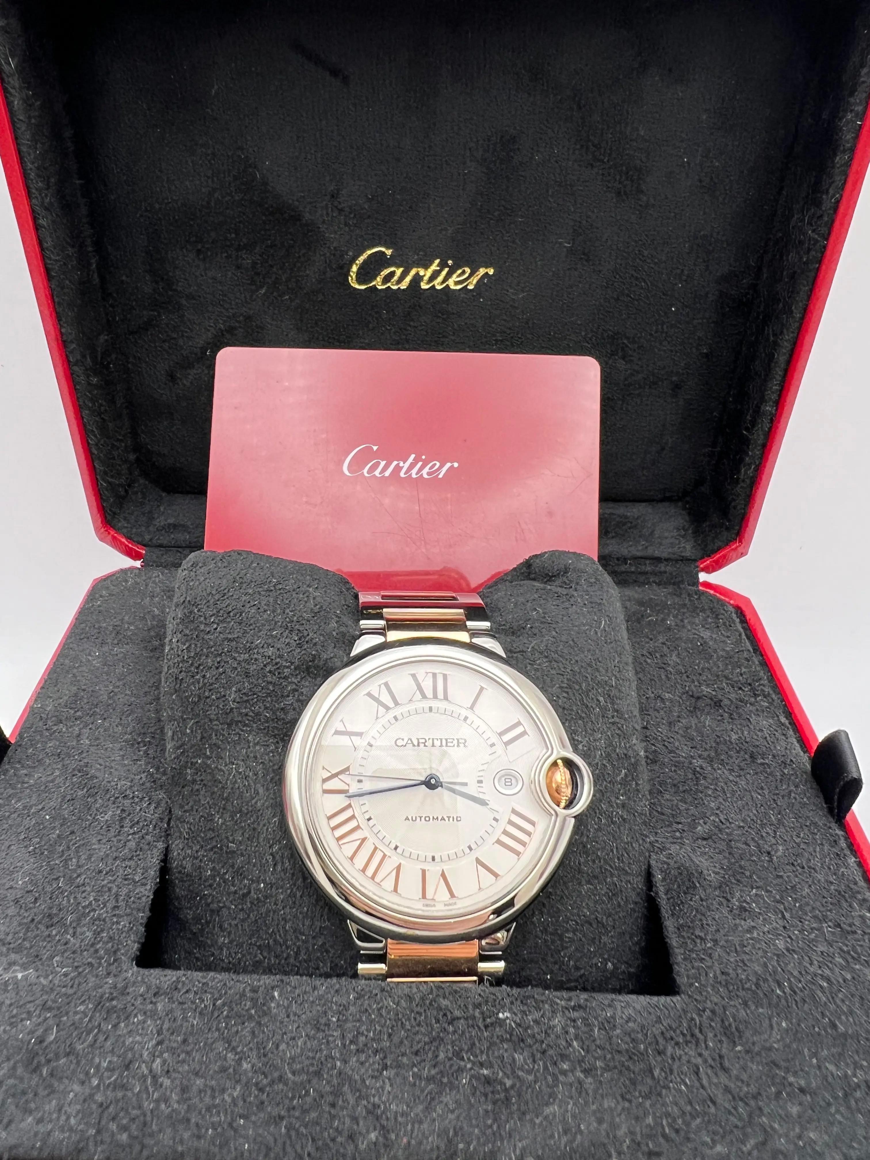 Cartier Ballon Bleu 42mm 18K Rose Gold & Steel Automatic Watch, Model W6920095. Silver Flinque Dial with Rose gold Roman Numerals and Date indicator, blue sword hands. Rose gold crown with Sapphire cabochon. Two tone 18K Rose Gold and Stainless