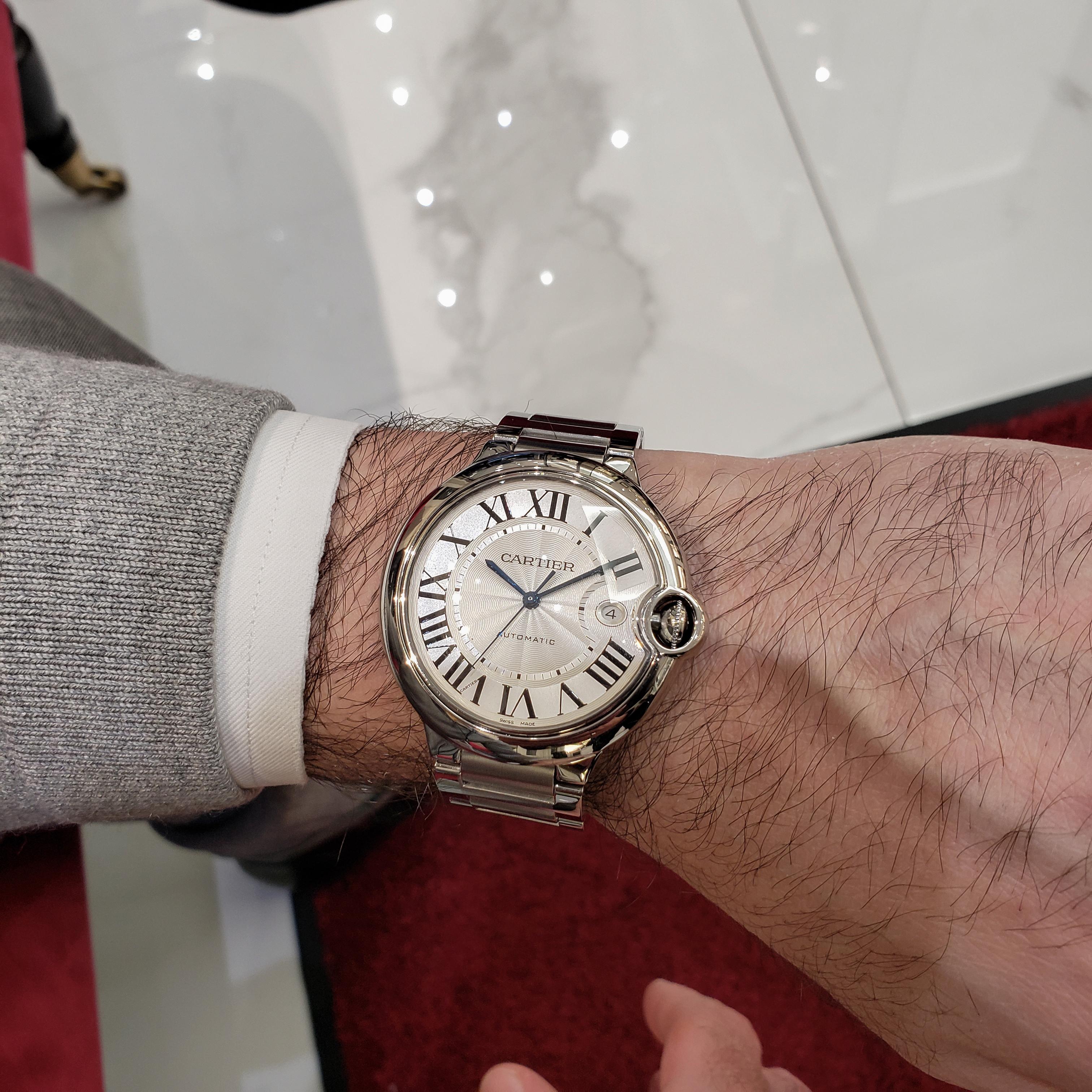 Made and Signed Cartier wristwatch. Model Ballon Bleu W69012Z4. Features a 42mm stainless steel case, and stainless steel bracelet with deployant clasp. Dial features roman numeral hour markers with a date in the 3 o'clock position. Minute markers