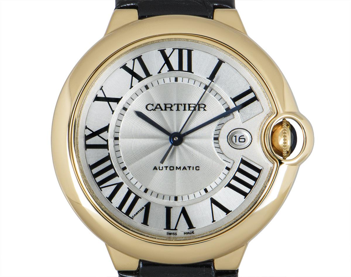 A yellow gold Ballon Bleu by Cartier, with a silver dial that features Roman numerals, sword-shaped hands in blued steel, the date at 3 o'clock and a secret Cartier signature at V of VII. The fluted crown is set with a sapphire cabochon. An original