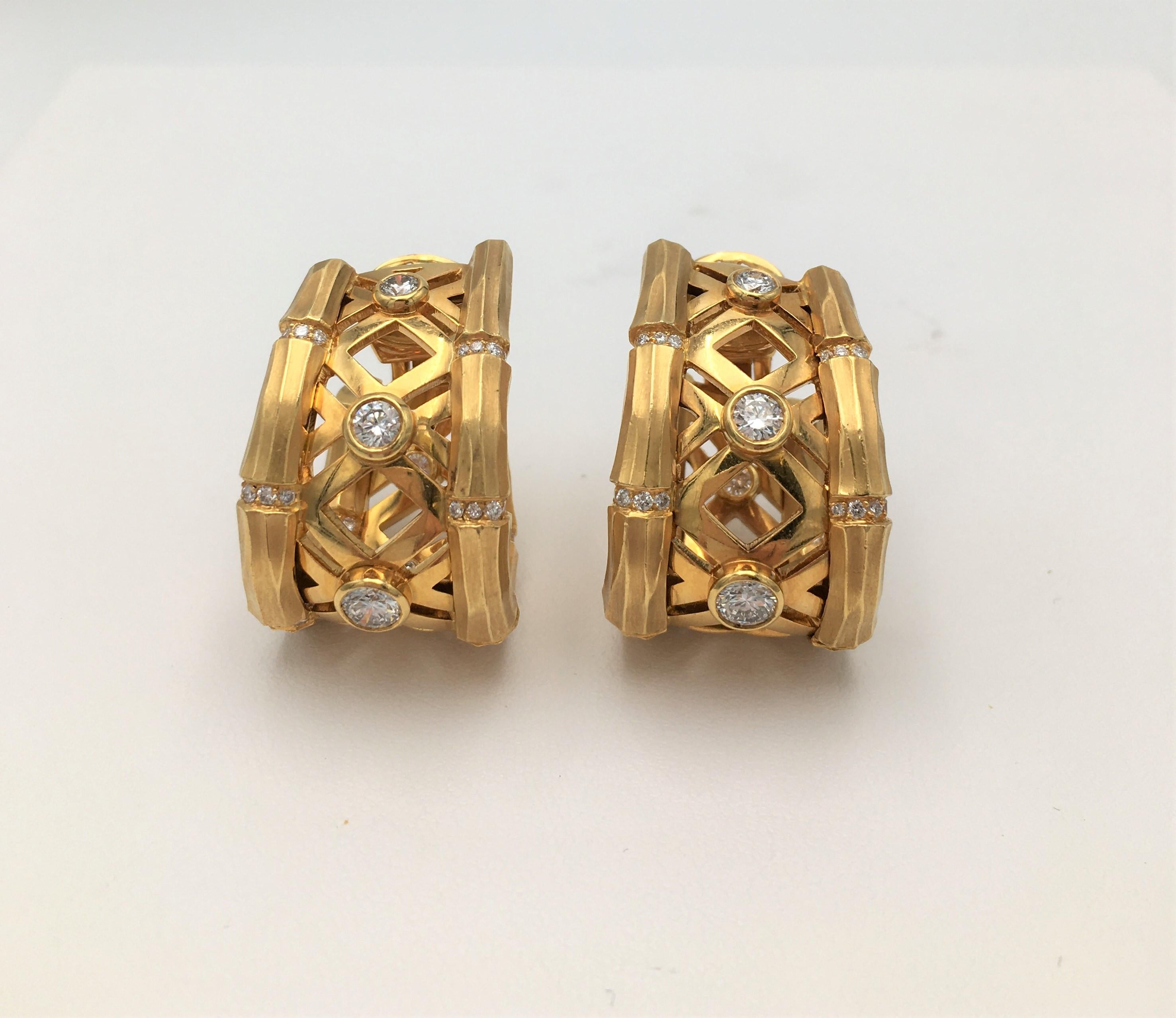 Authentic Cartier 'Bamboo' hoop earrings feature bezel set high-quality round brilliant diamonds weighing an estimated 1.45 carats total. Crafted in 18 karat yellow brushed gold the bamboo links are connected by rows of smaller round brilliant cut