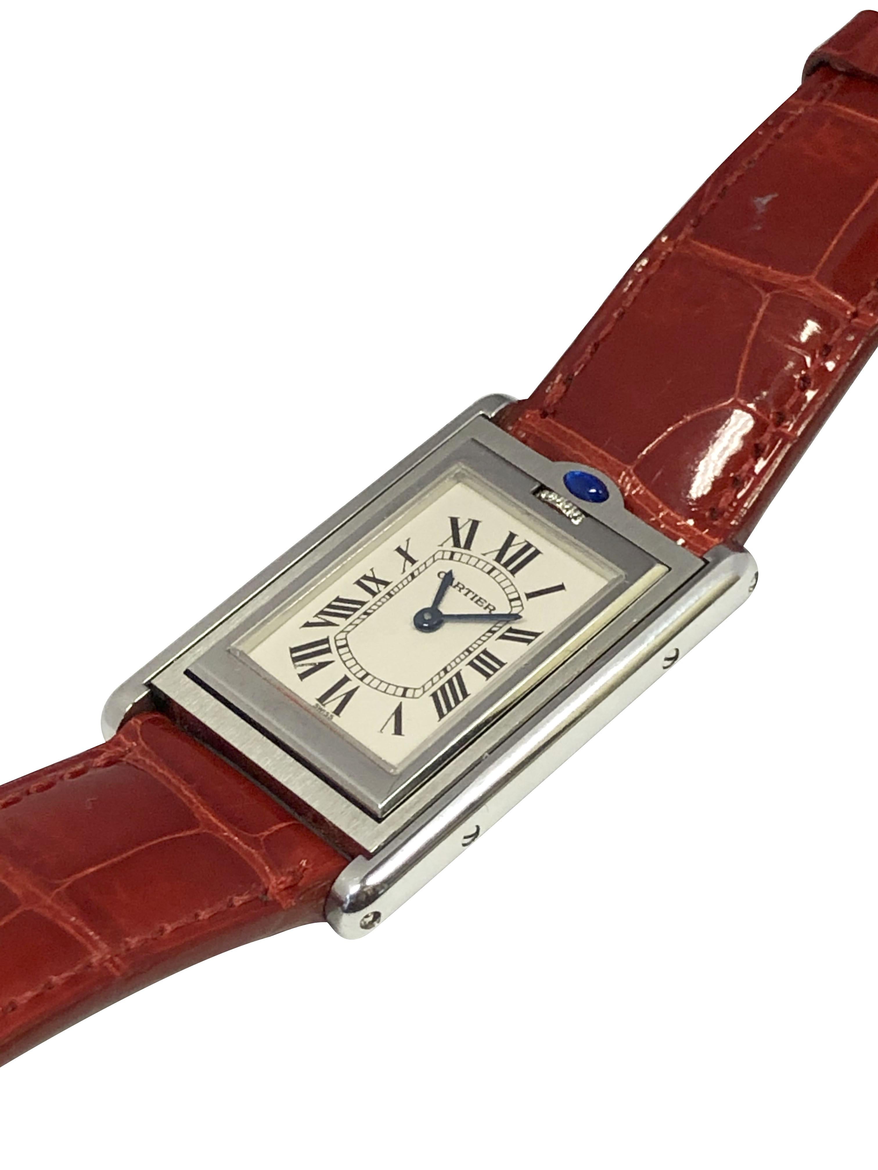 Circa 2000 Cartier Basculante Wrist Watch, 27 X 23.5 M.M. Stainless Steel 3 Piece case. Quartz movement, Silver White dial with Black Roman numerals and a Cabochon Sapphire at the pull to flip the watch. Original Red leather strap with Steel Tang