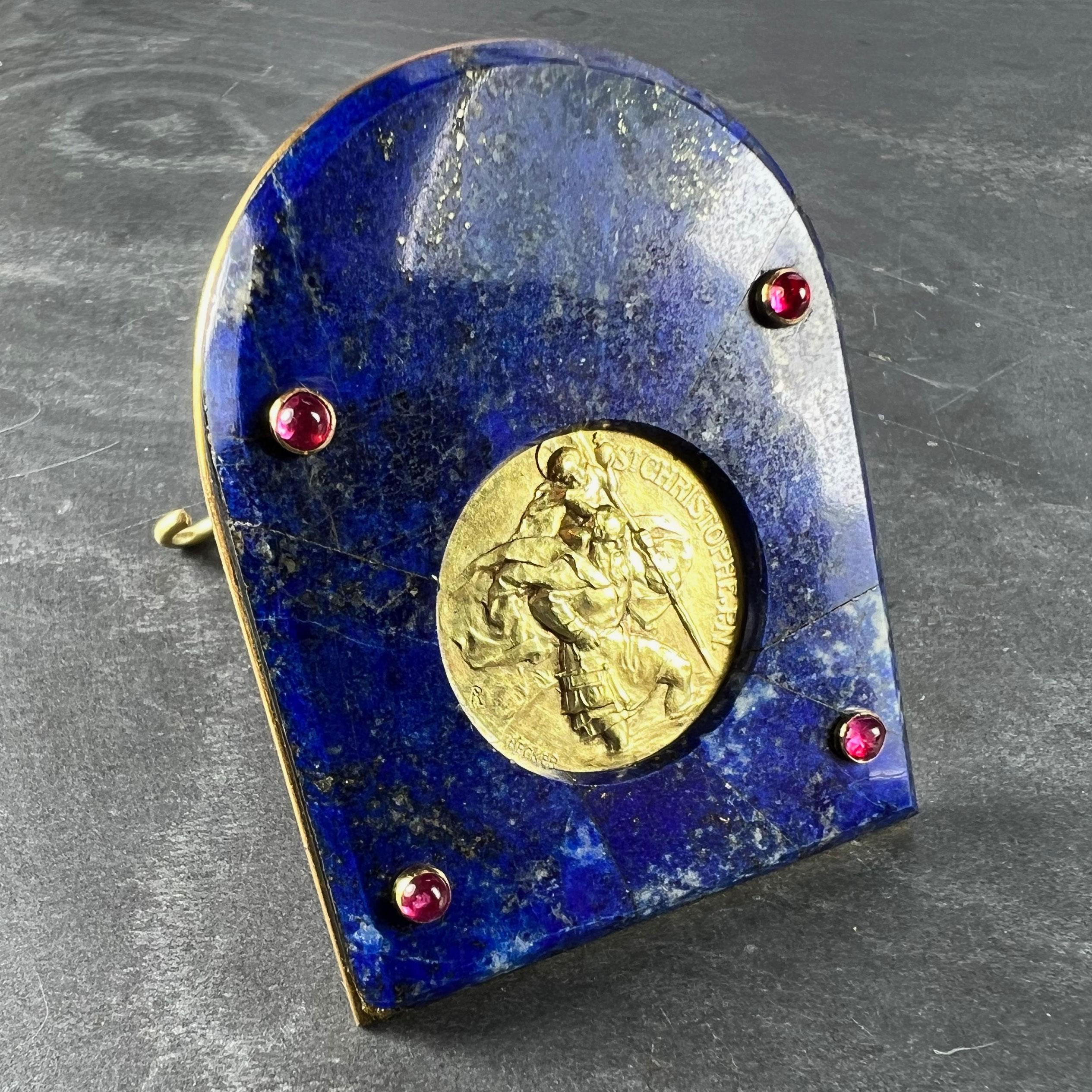 Un ornement de bureau Cartier conçu comme un cadre en lapis-lazuli serti d'une grande médaille française en or jaune 18 carats (18K) représentant Saint Christophe portant l'enfant Christ sur la rivière. La médaille est signée Becker. La médaille