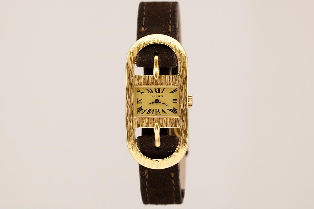This rare and unique Cartier wristwatch designed by the iconic Italian designer Roberta Di Camerino, circa 1975. The highly stylized 18kt yellow gold case is in the shape of a buckle with a small rectangular dial right in the middle. The gold tone