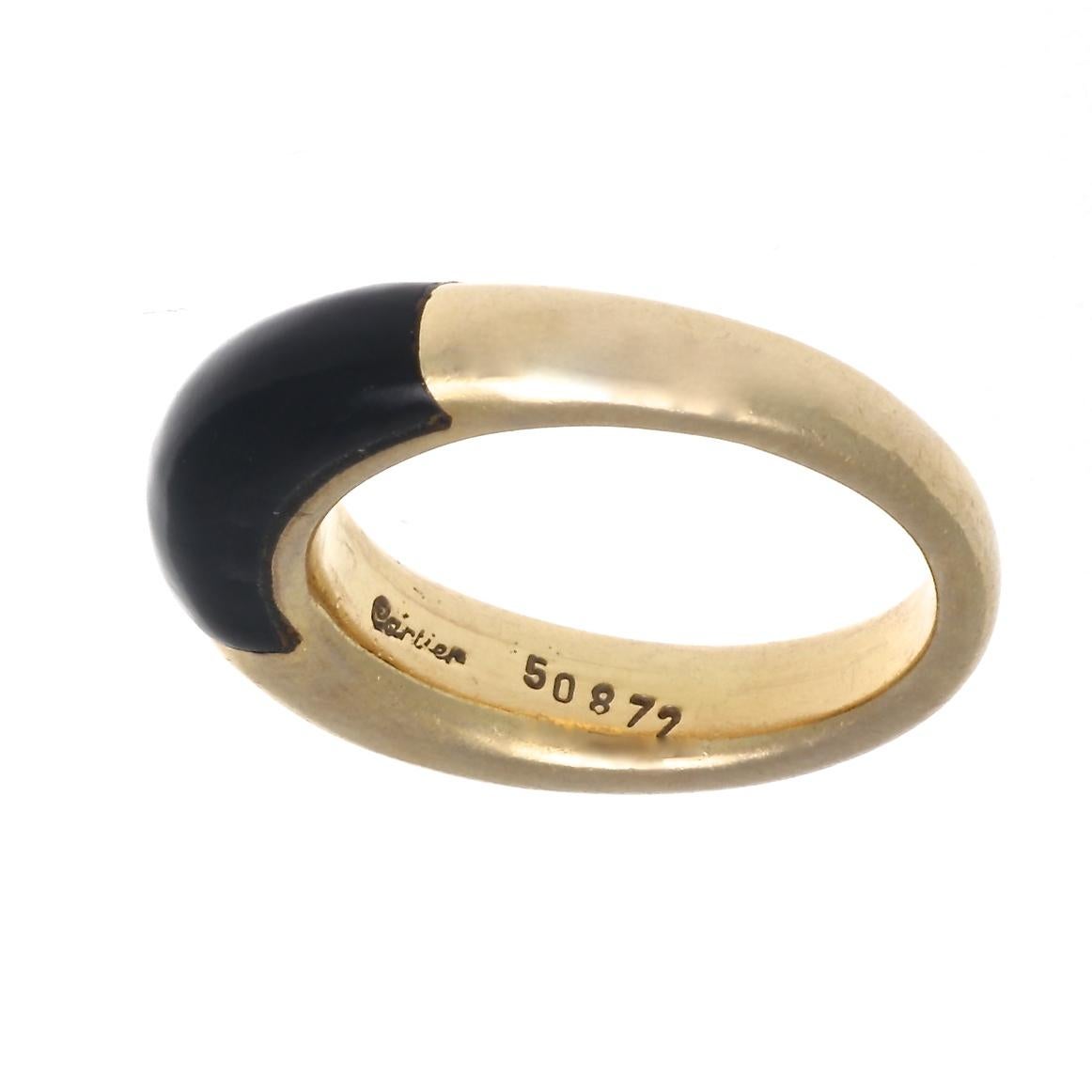 Undeniable style that is fashion sensible. Featuring a graceful contour of glistening 18k gold that is perfectly matched with black enamel. Signed Cartier and numbered. Ring size 5 3/4 and may be re-sized to fit.