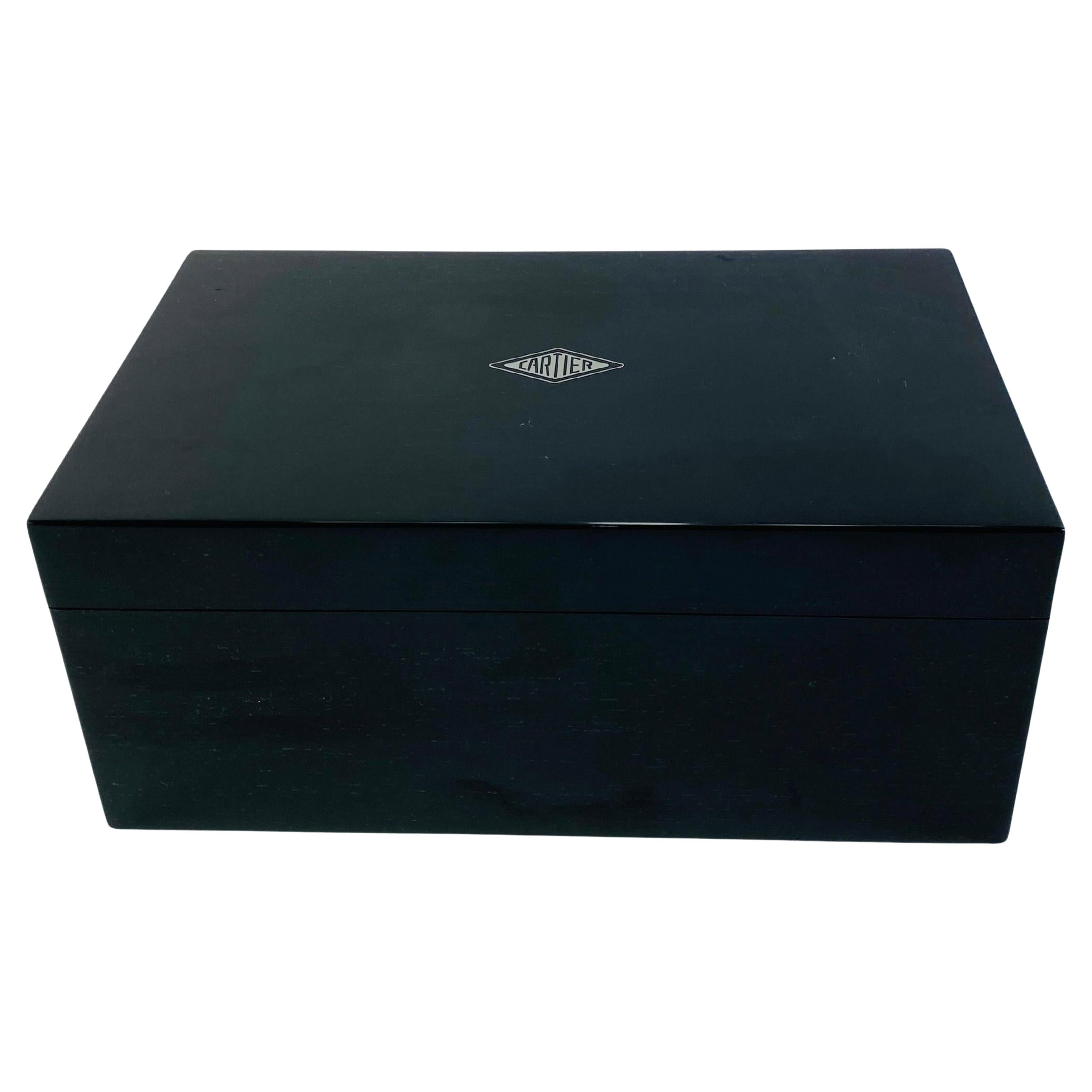 Cartier Scatola per orologi laccata nera 

Con tre scomparti per orologi dotati di interni in pelle scamosciata grigia, minuteria metallica cromata con marchio Cartier sulla parte superiore del coperchio


