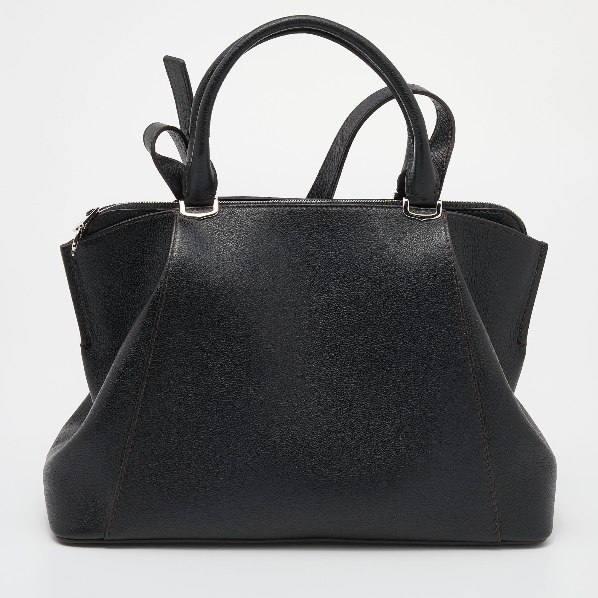 The C De Cartier tote has a classy silhouette and a functional quality. Constructed using leather, the bag has two handles, a shoulder strap, and a fabric-lined interior. The signature on the front gives it a luxe slant.

Includes: Original Dustbag,