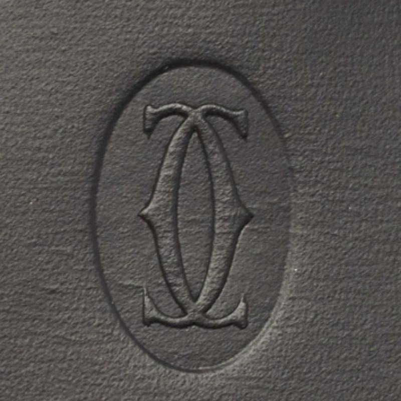 Il portapenne Cartier è un accessorio di lusso progettato per conservare e proteggere con eleganza i tuoi strumenti di scrittura. Realizzato in pregiata pelle nera, presenta una chiusura a patta per riporlo in modo sicuro e un design elegante e